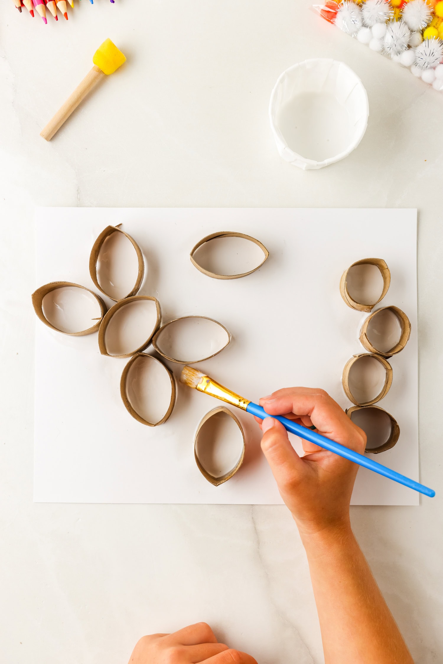 Painting down butterfly toilet paper pieces on cardstock for Butterfly Life Cycle Craft