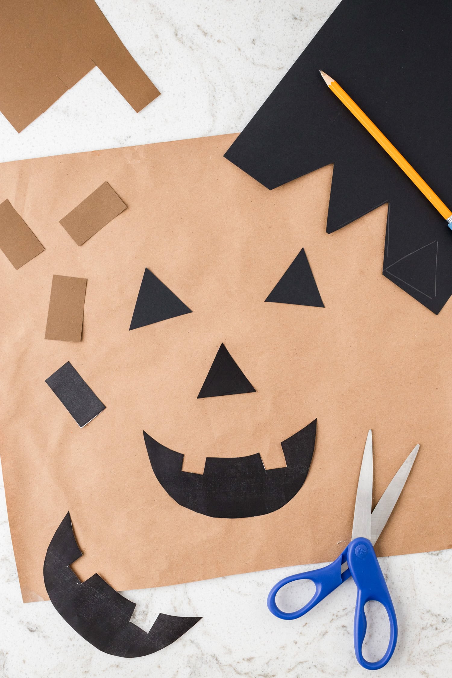 Tracing and cutting a jack-o-lantern face from template for Paper Plate Pumpkin Craft