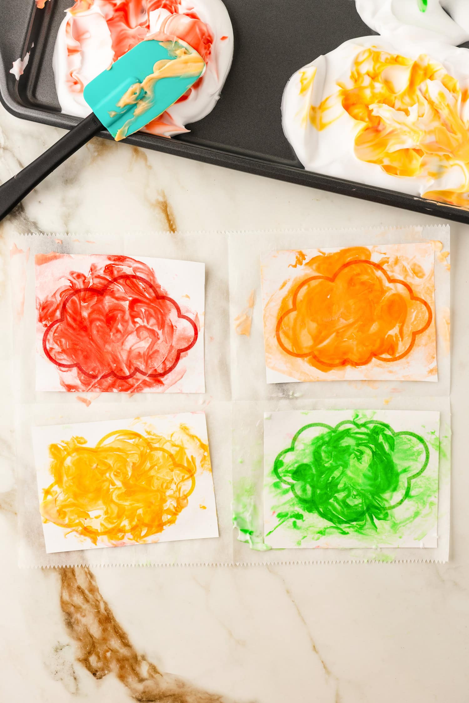 Colored shaving cream pressed onto cloud printouts on white cardstock for Toilet Paper Roll Fall Tree Craft