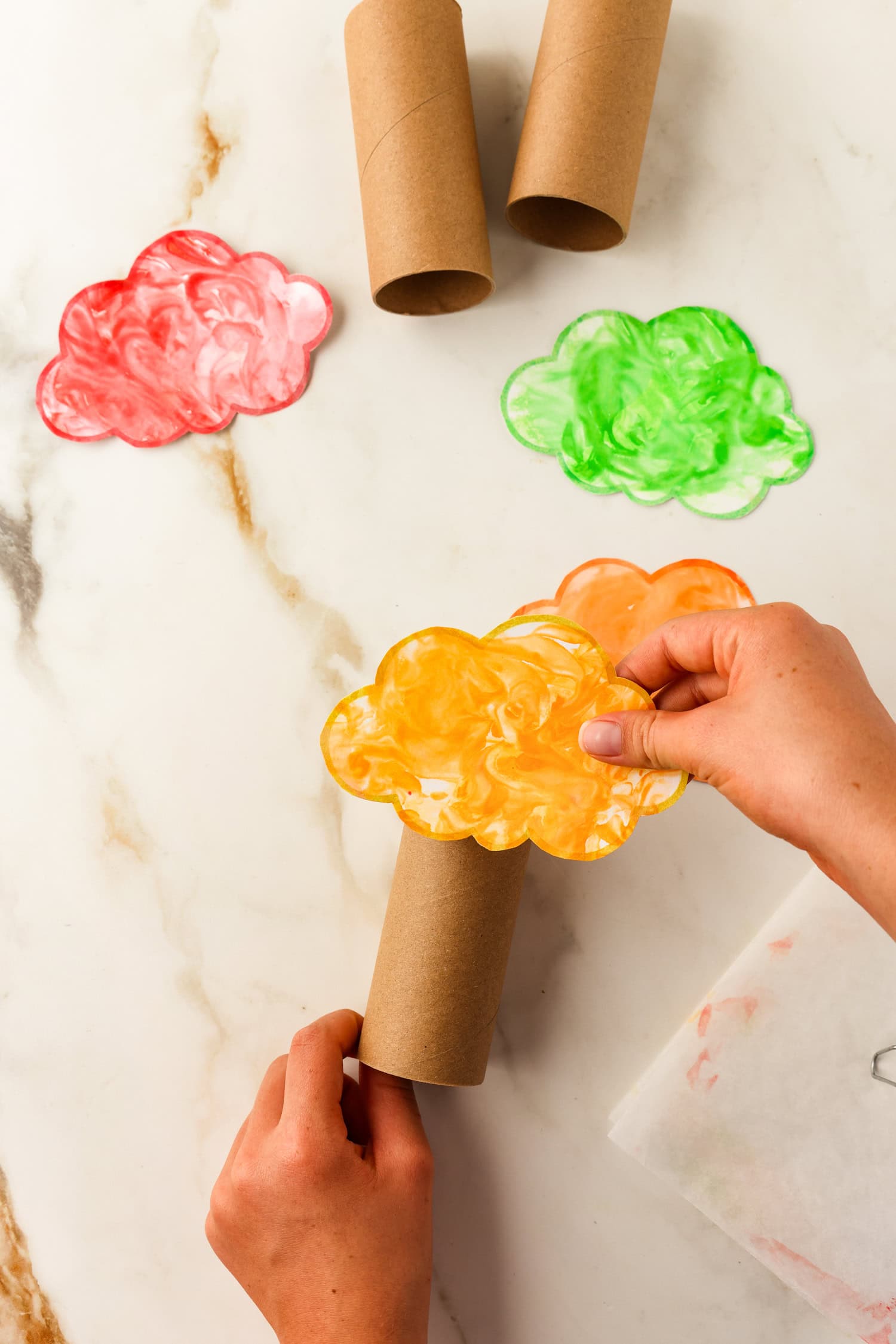 Pressing the tree topper to the toilet paper roll for the Toilet Paper Roll Fall Tree Craft