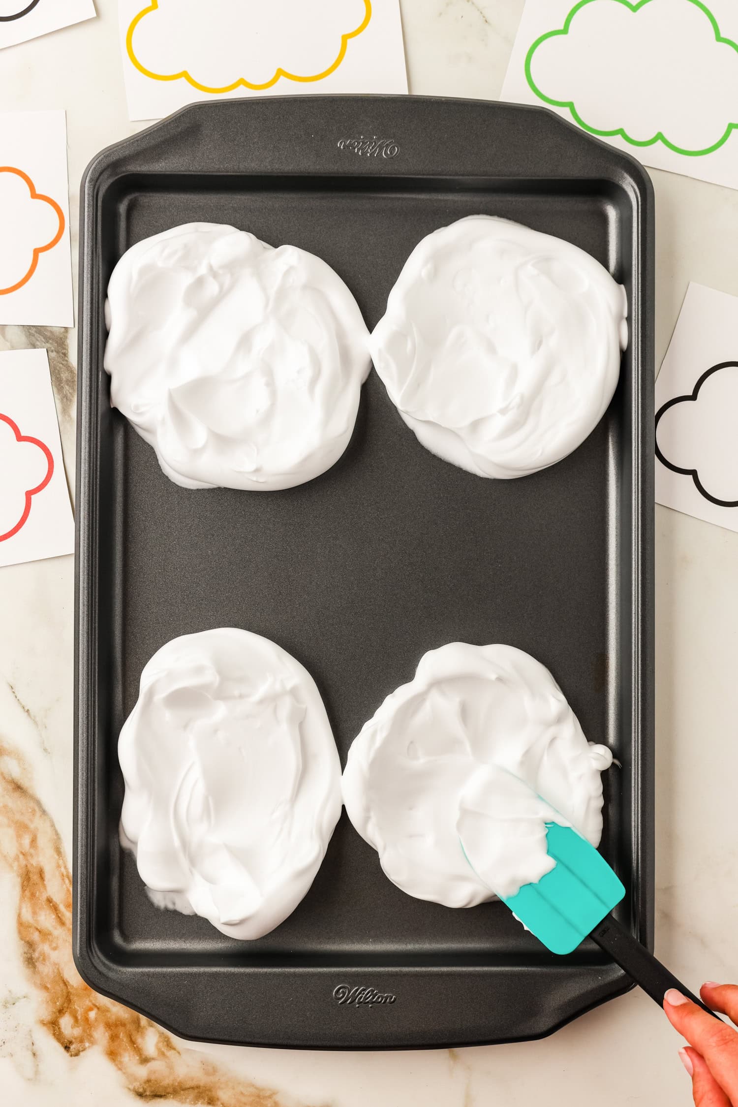 Using a spatula to spread the shaving cream clouds on sheet pan for Toilet Paper Roll Fall Tree Craft