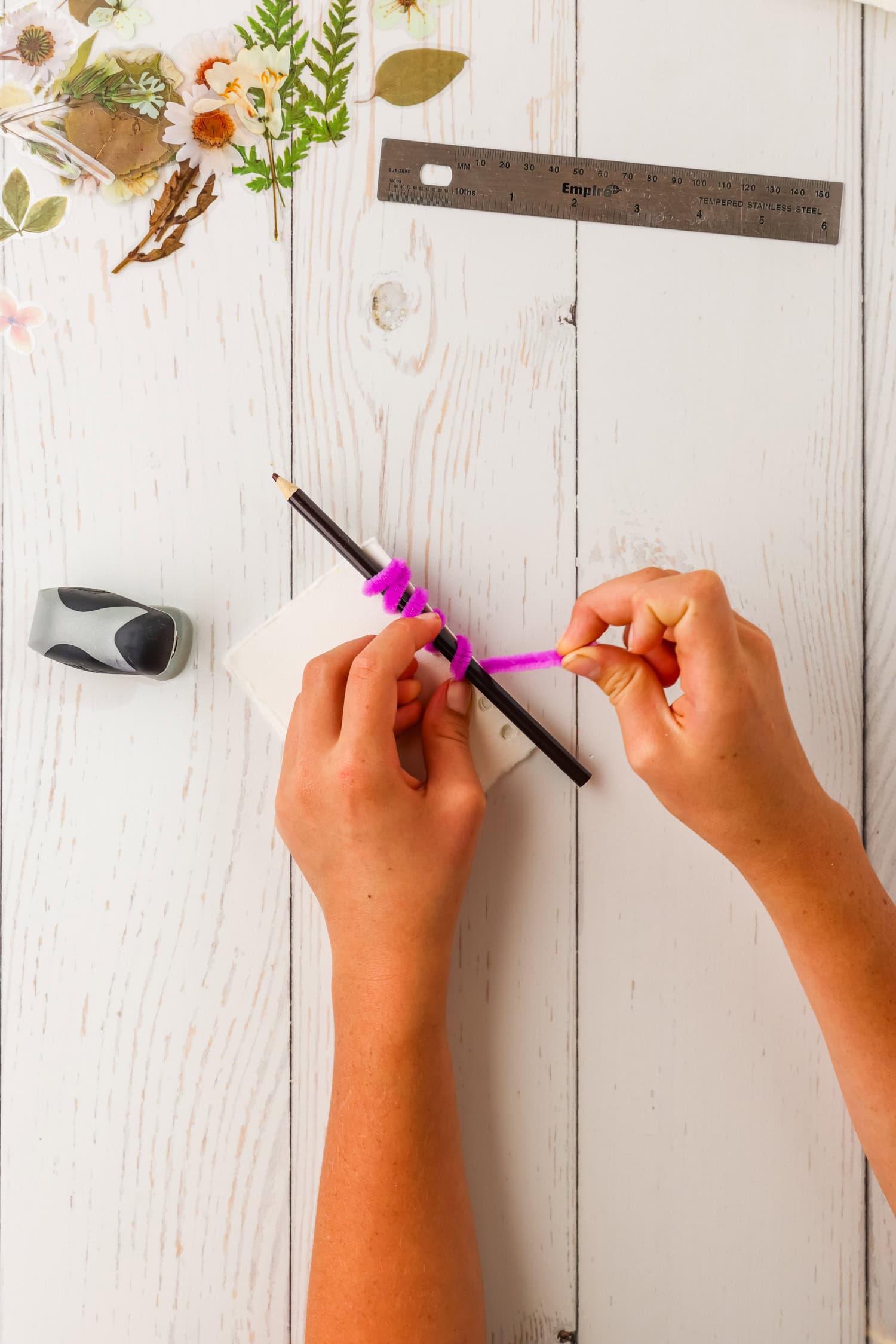 Using a pencil to coin pipecleaner in DIY Sticker Book