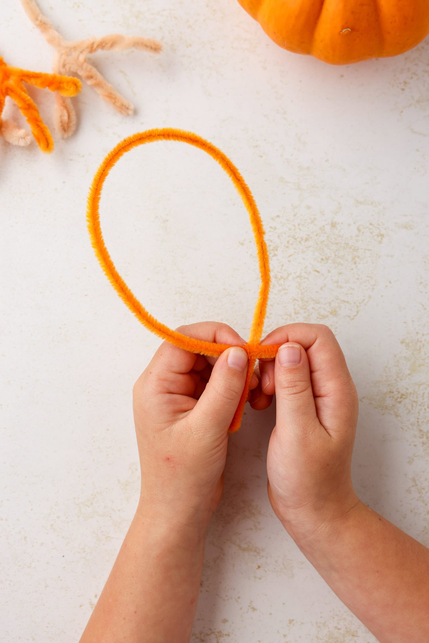 Using a pipe cleaner, form a turkey foot by making a balloon shape, making sure to leave a short &ldquo;stem&rdquo; at the bottom. Once the balloon is formed, twist the pipe cleaner around itself to hold it in place for Turkey Craft