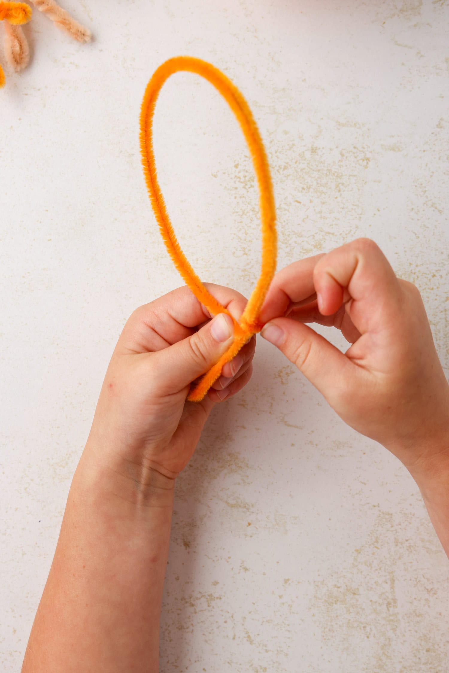 Using a pipe cleaner, form a turkey foot by making a balloon shape, making sure to leave a short &ldquo;stem&rdquo; at the bottom. Once the balloon is formed, twist the pipe cleaner around itself to hold it in place for Turkey Craft
