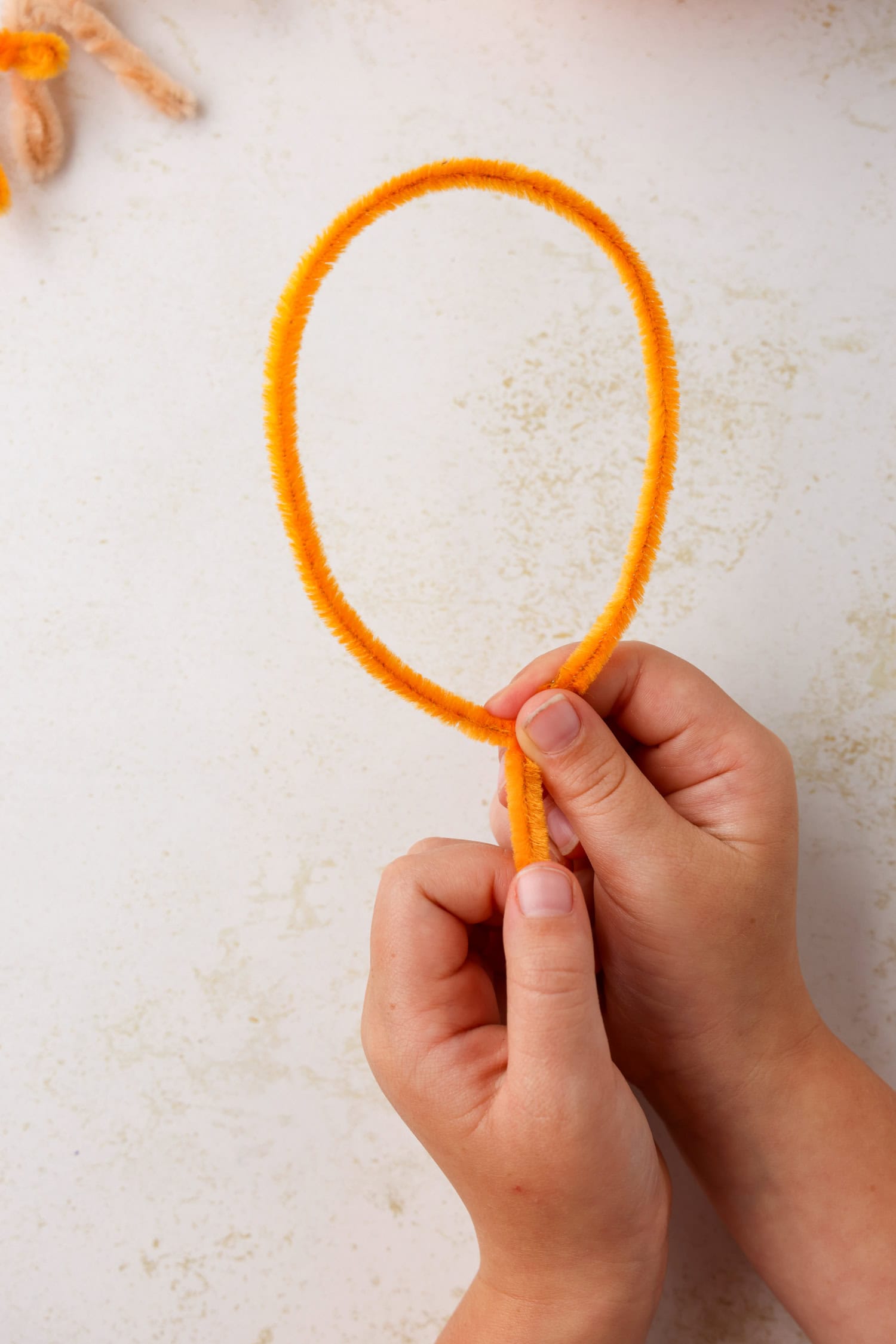 Using a pipe cleaner, form a turkey foot by making a balloon shape, making sure to leave a short &ldquo;stem&rdquo; at the bottom. Once the balloon is formed, twist the pipe cleaner around itself to hold it in place for Turkey Craft