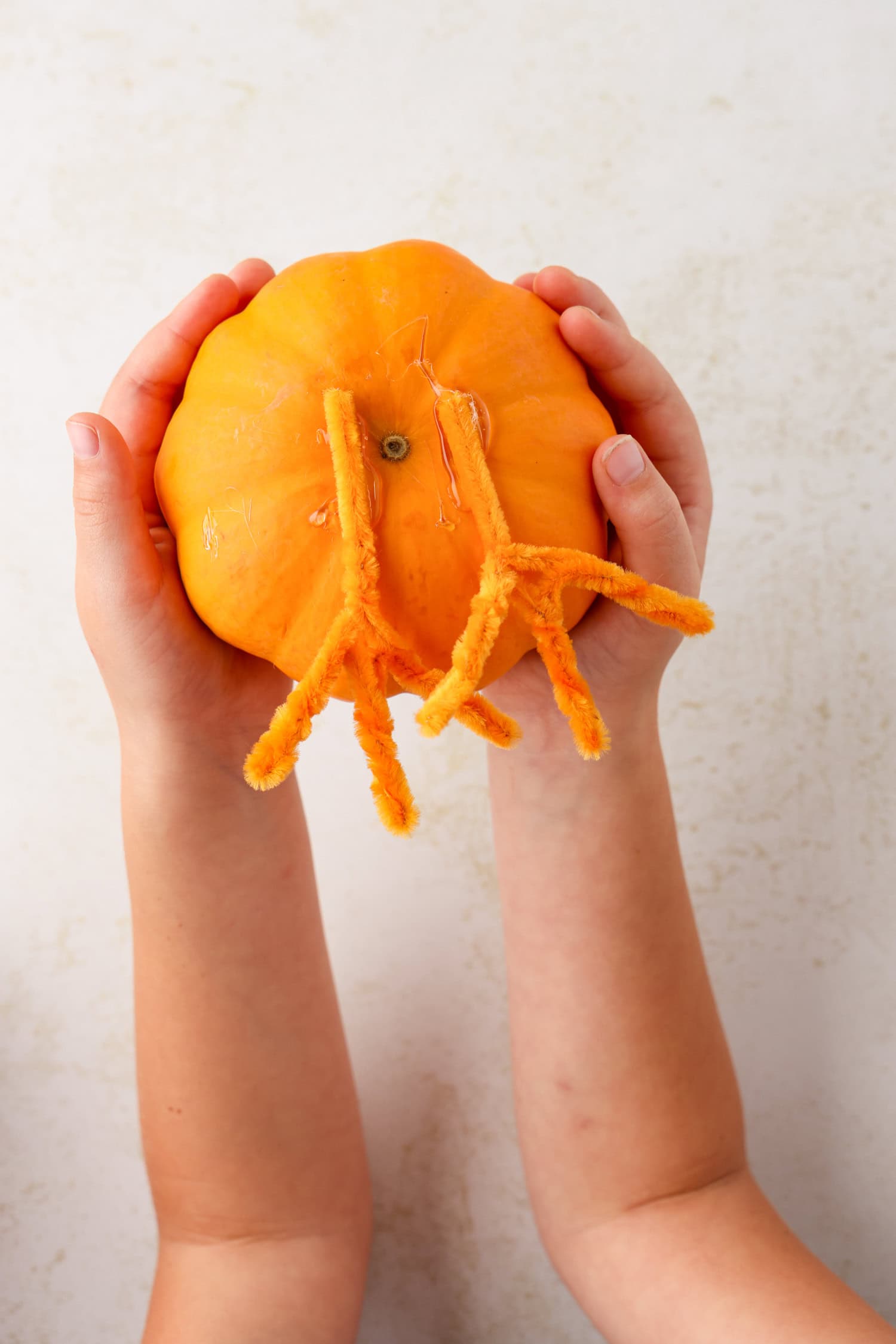 Use a little bit of hot glue to attach each foot to the bottom of the pumpkin for the Turkey Craft