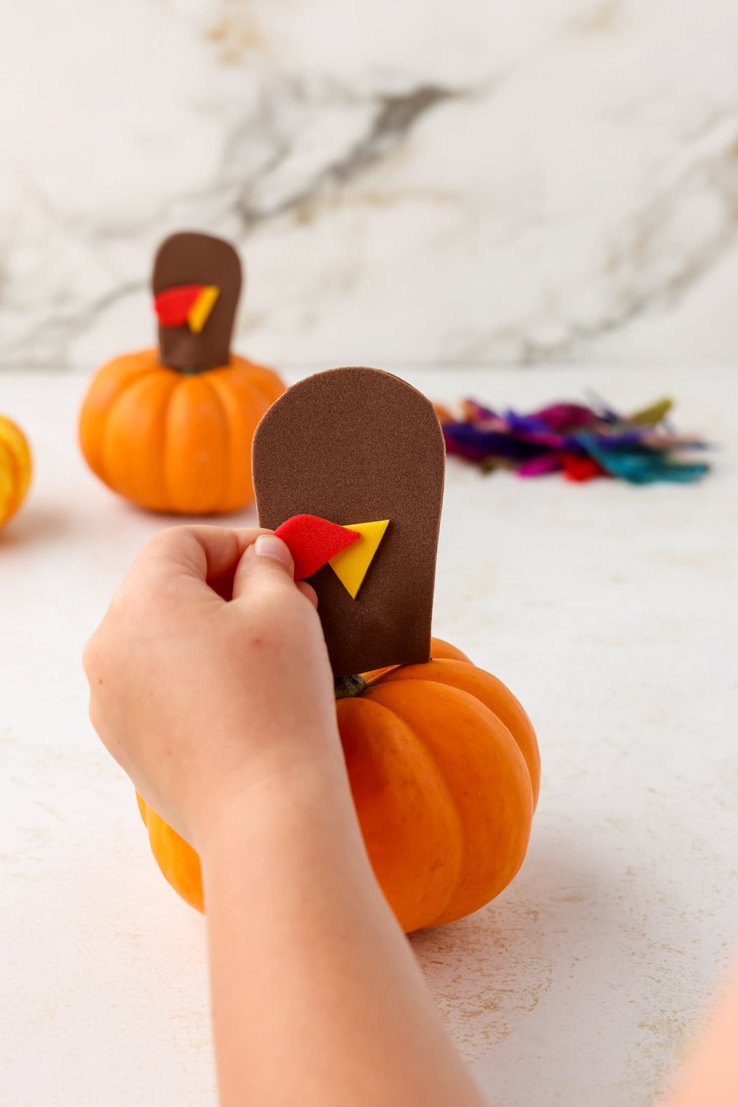 Adding red turkey snood to head for Mini Pumpkin Turkey Craft