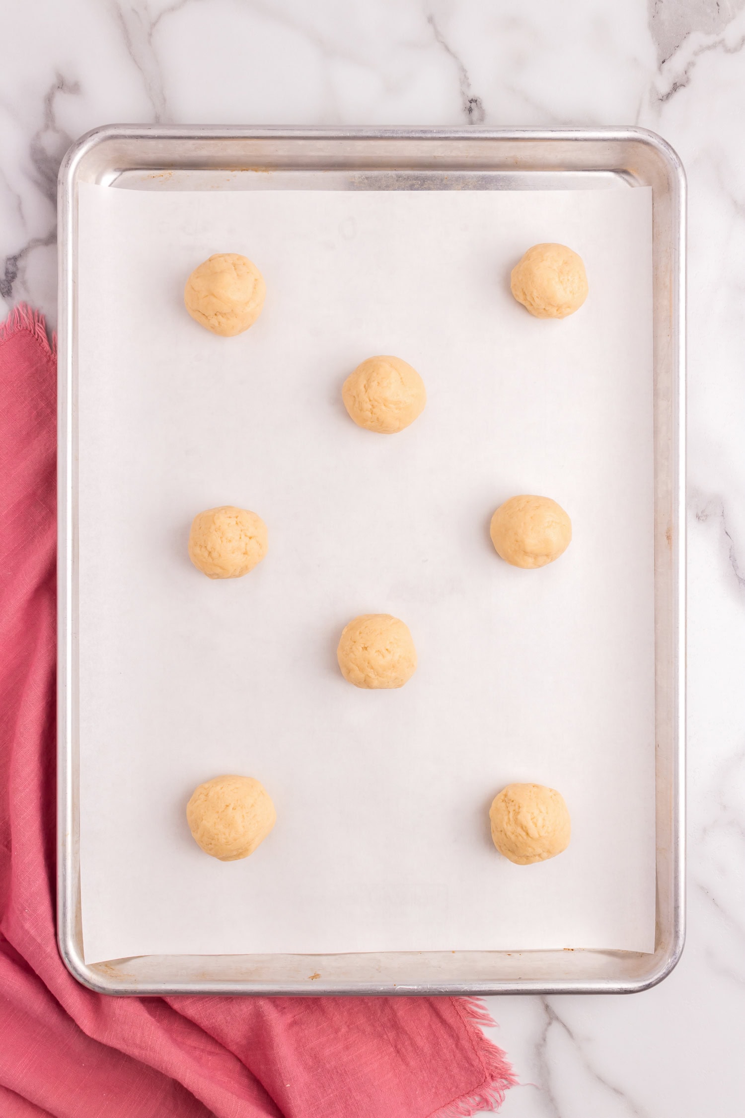 Sour Cream Cookies dough balls on parchment-lined paper on sheet pan