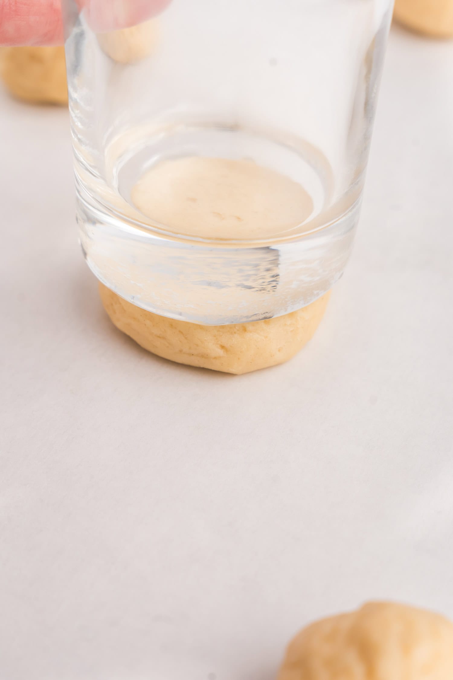 Using glass to press down Sour Cream Cookie dough balls