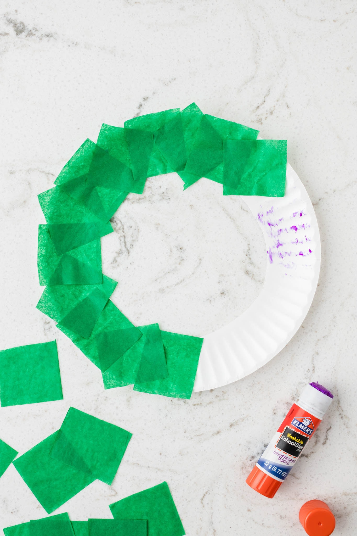 Overhead picture of square tissue paper glued onto the paper plate.