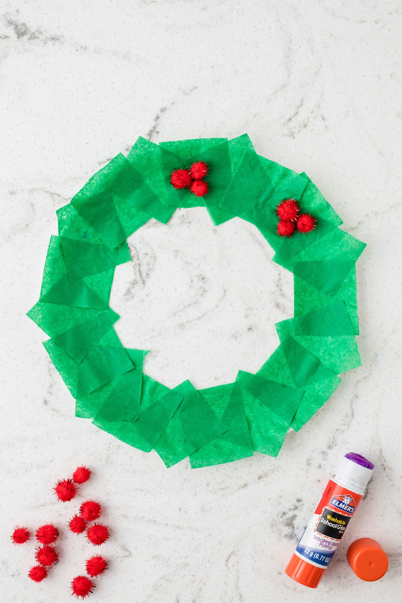 Overhead picture of pom poms glued in bundles of 3 onto the tissue paper.