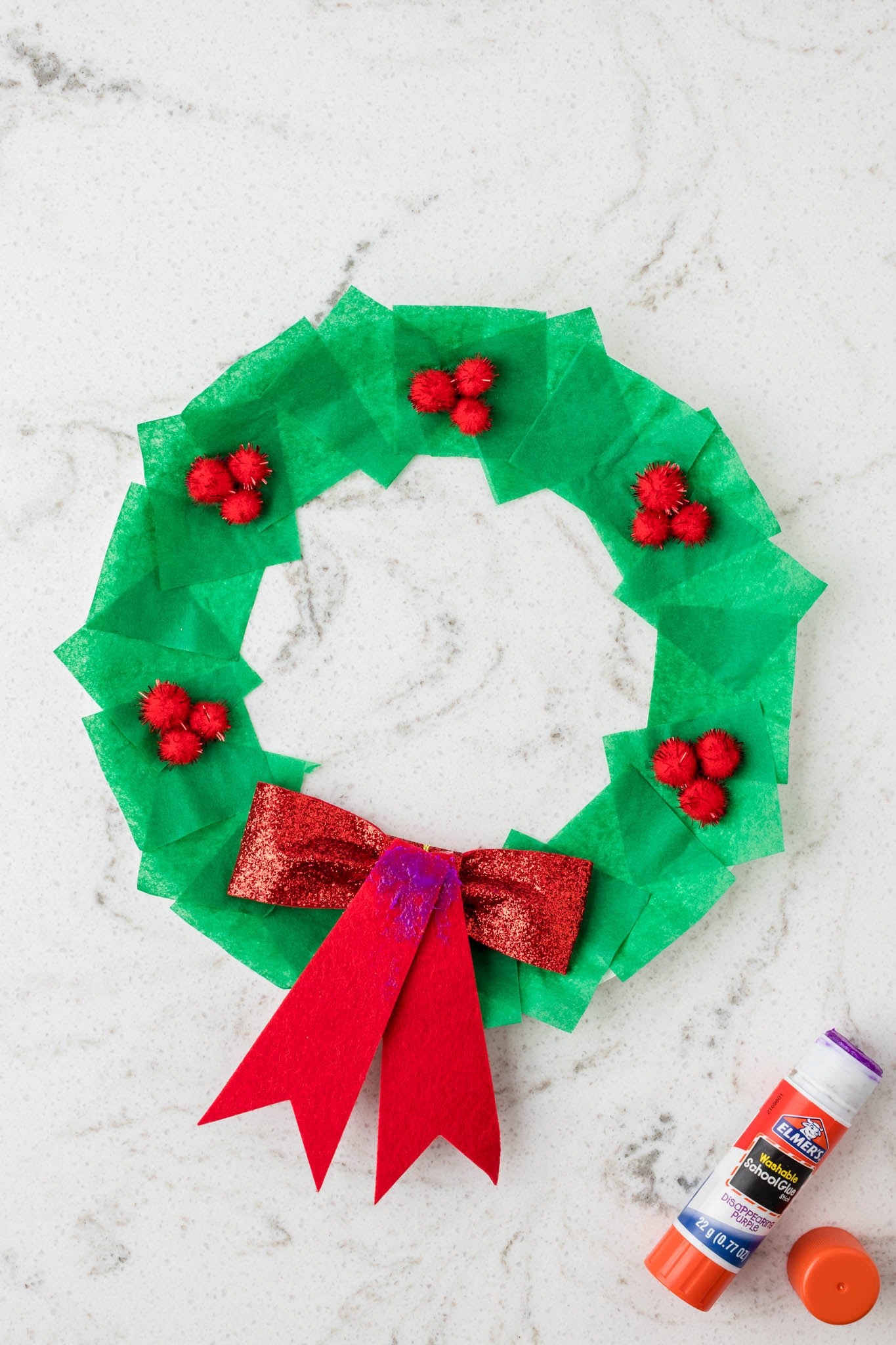Overhead picture of wreath with bow flipped over and purple glue on it.