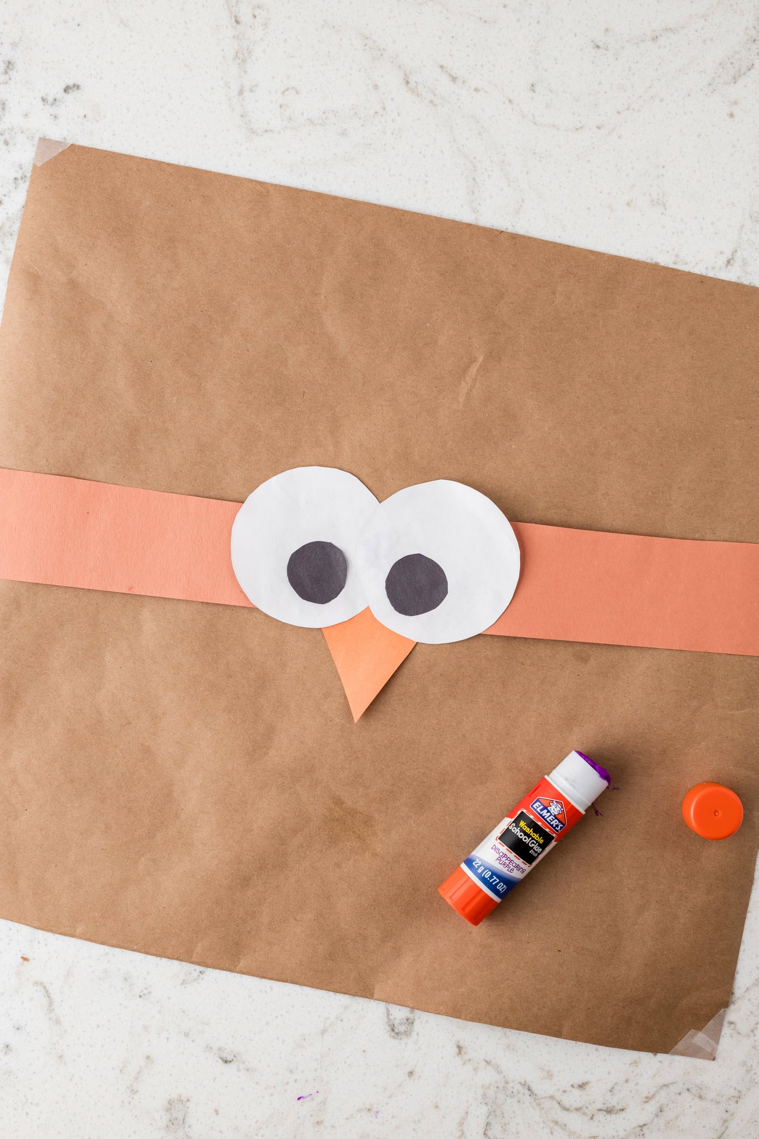 Adding white and black circles to the headband with glue for the Turkey Headband Craft