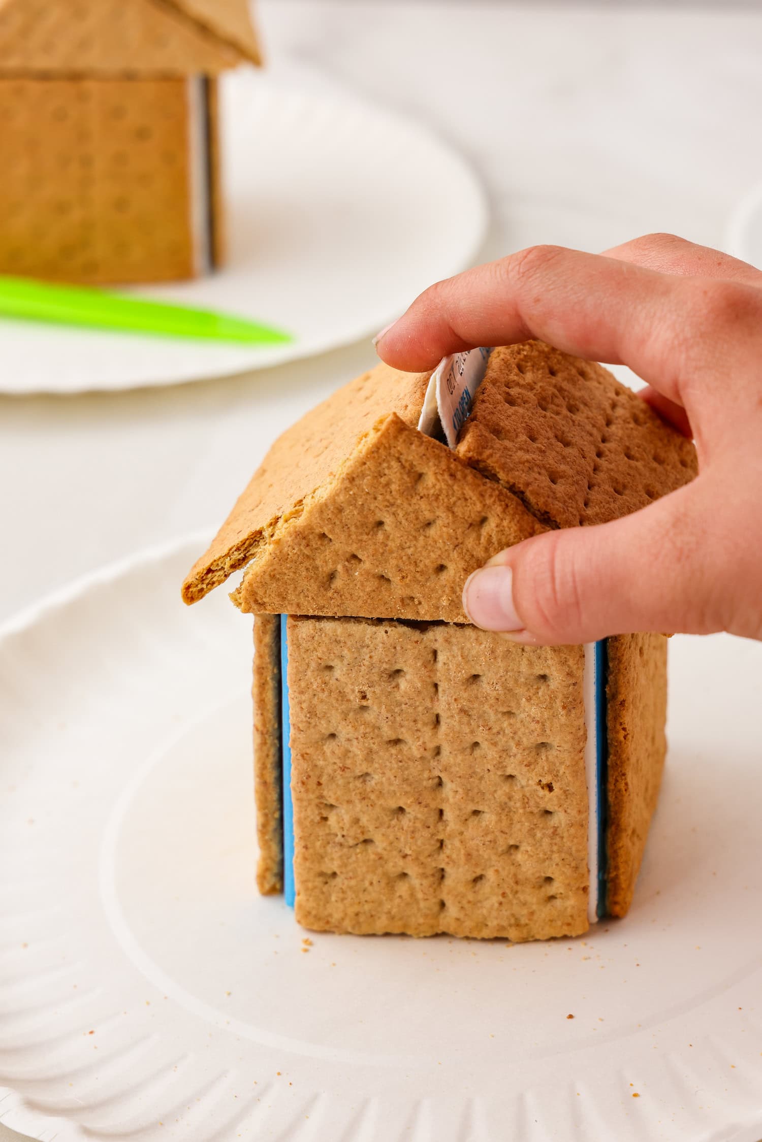 Picture of putting the graham cracker walls onto the milk carton.