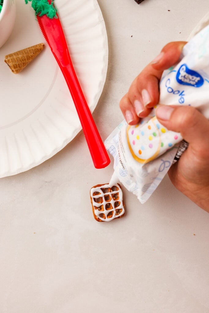 Overhead picture of putting icing on a square pretzel.
