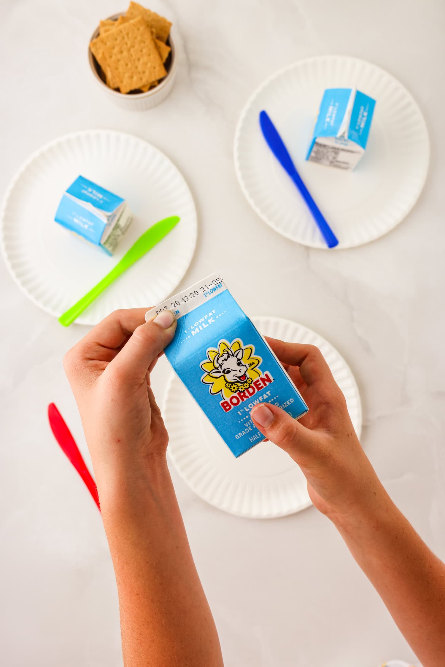 Overhead picture of hand squeezing the milk carton opening closed.