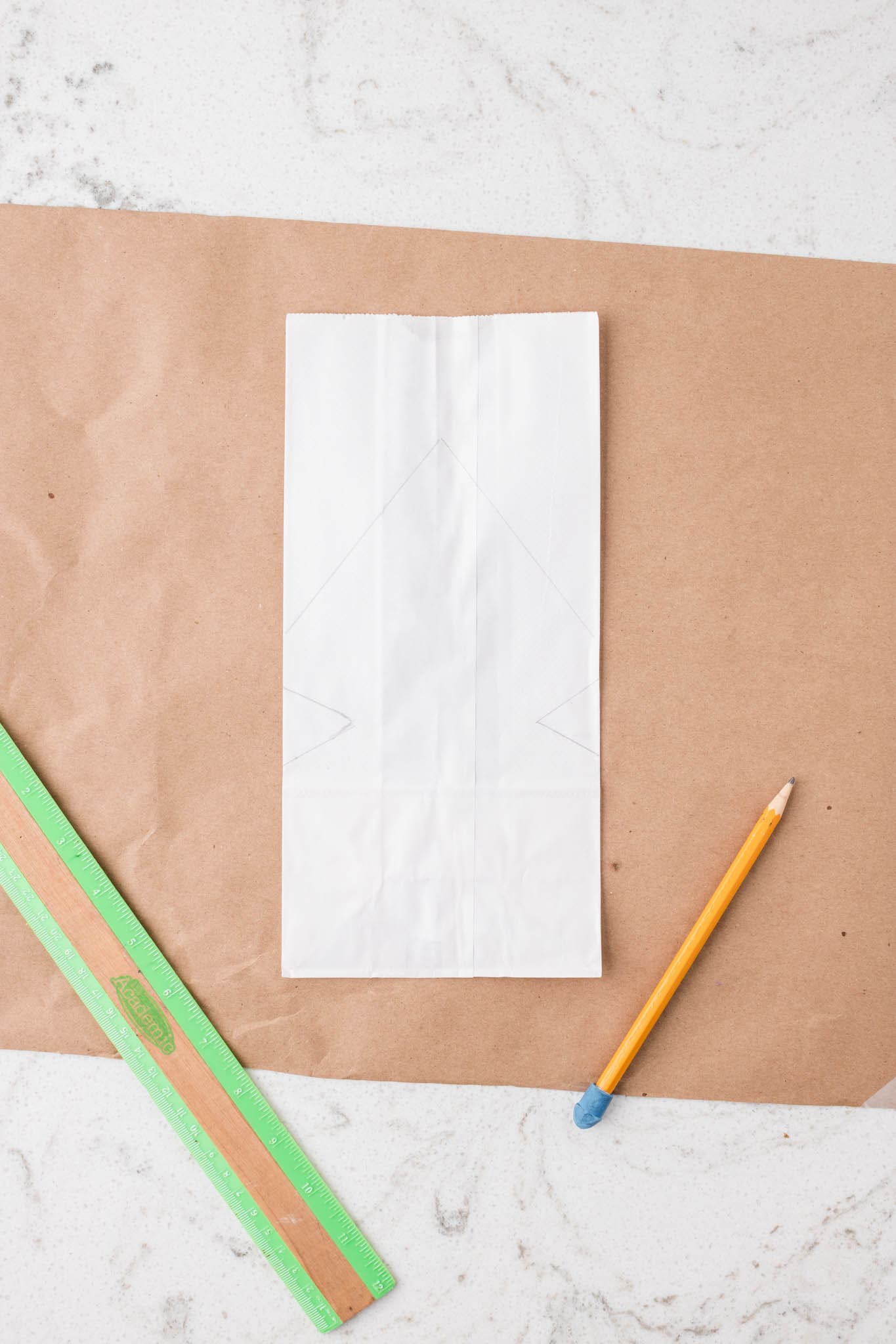 Overhead picture of white paper bag with a stencil drawn on it.