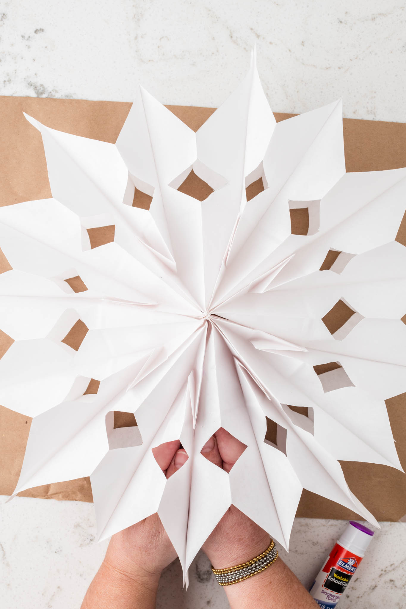 Overhead picture of completed paper bag snowflake.