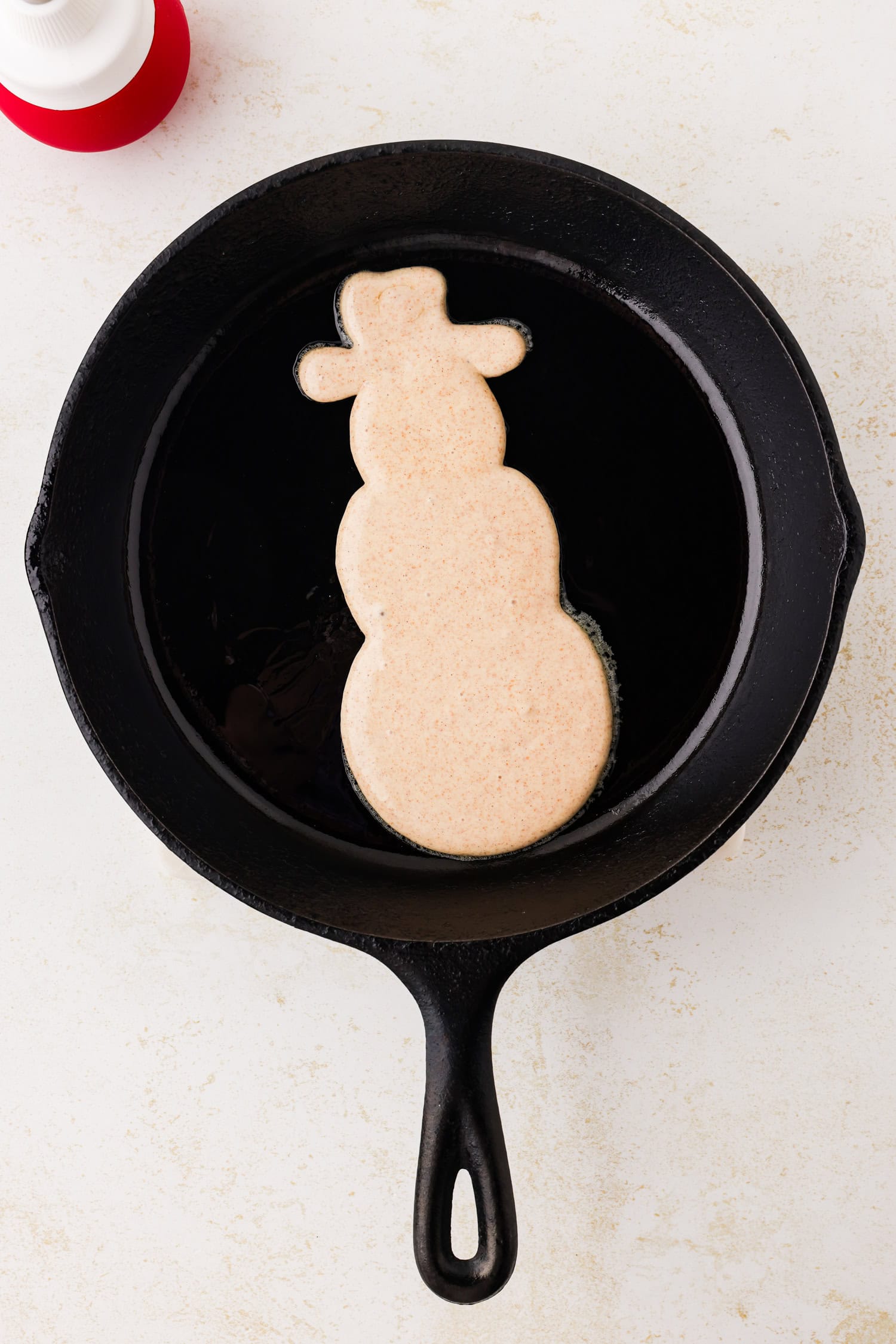 Snowman pancake in the skillet.