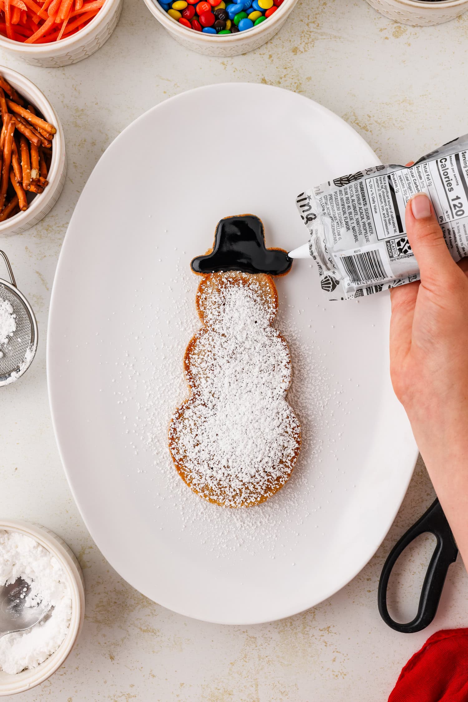 Snowman pancakes hat being frosted on.