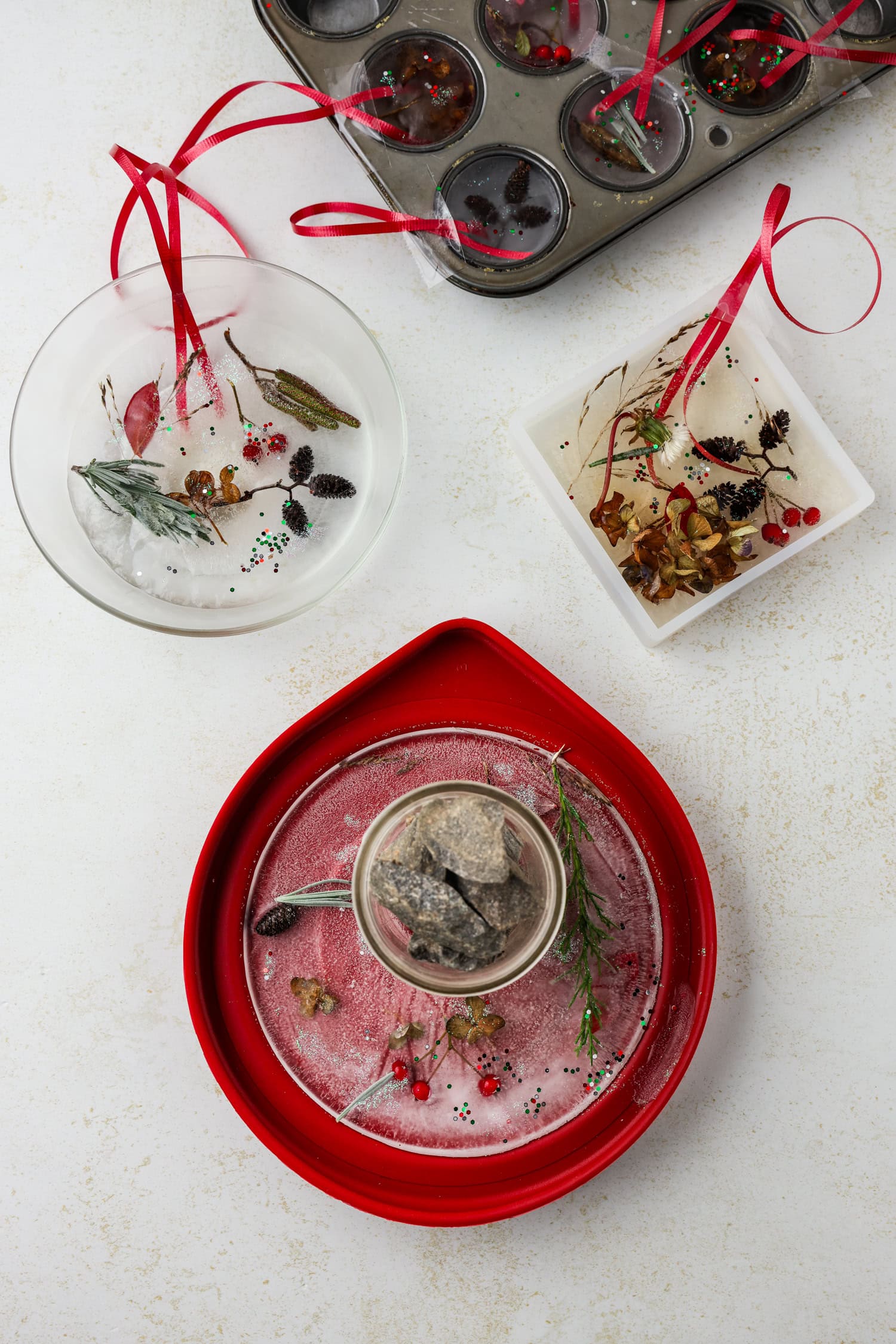 Picture of 3 separate containers with frozen ice suncatchers and ribbon in them.