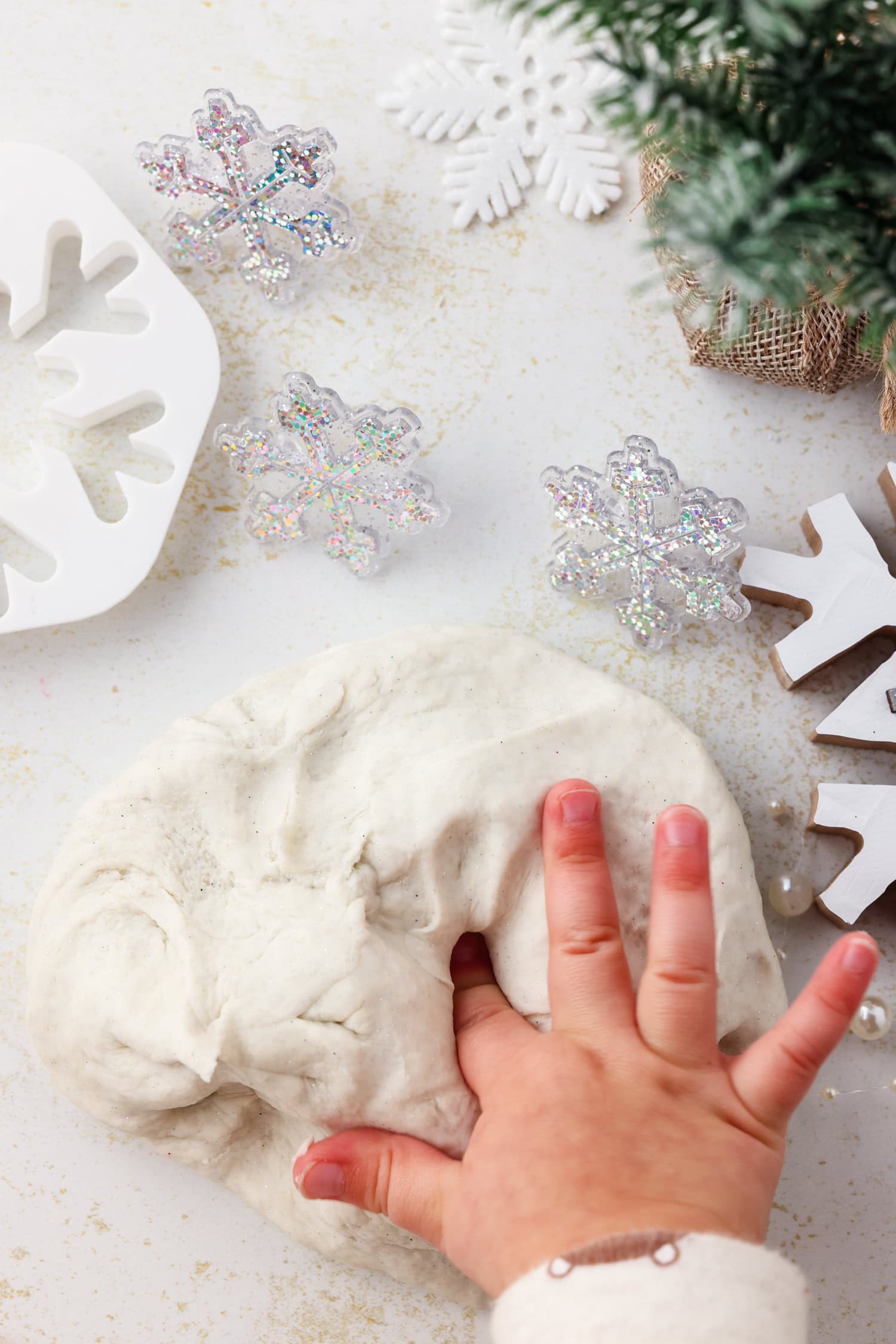 Kids hand pushing into snow dough