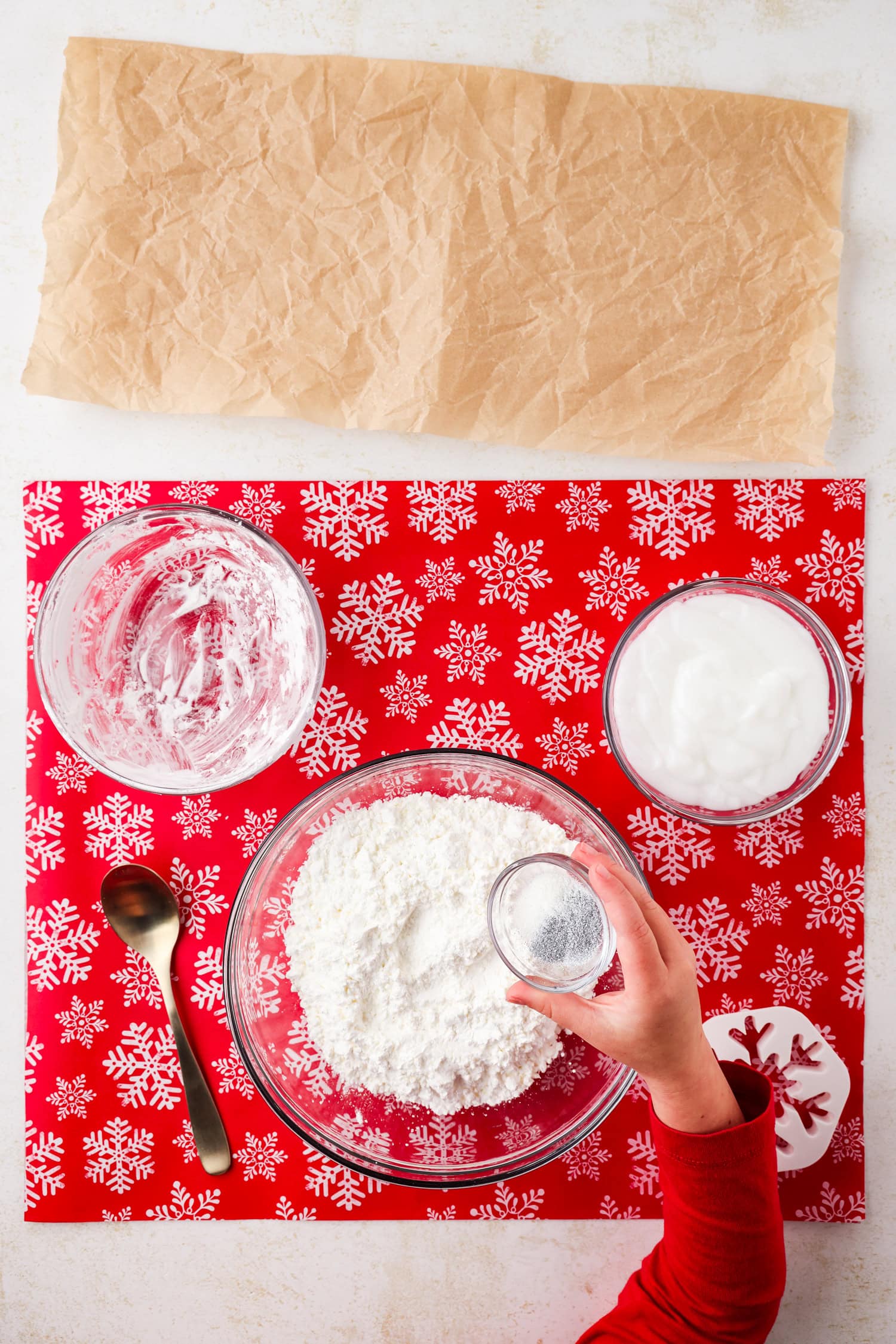 Overhead picture of all ingredients with hand holding small bowl of glitter.