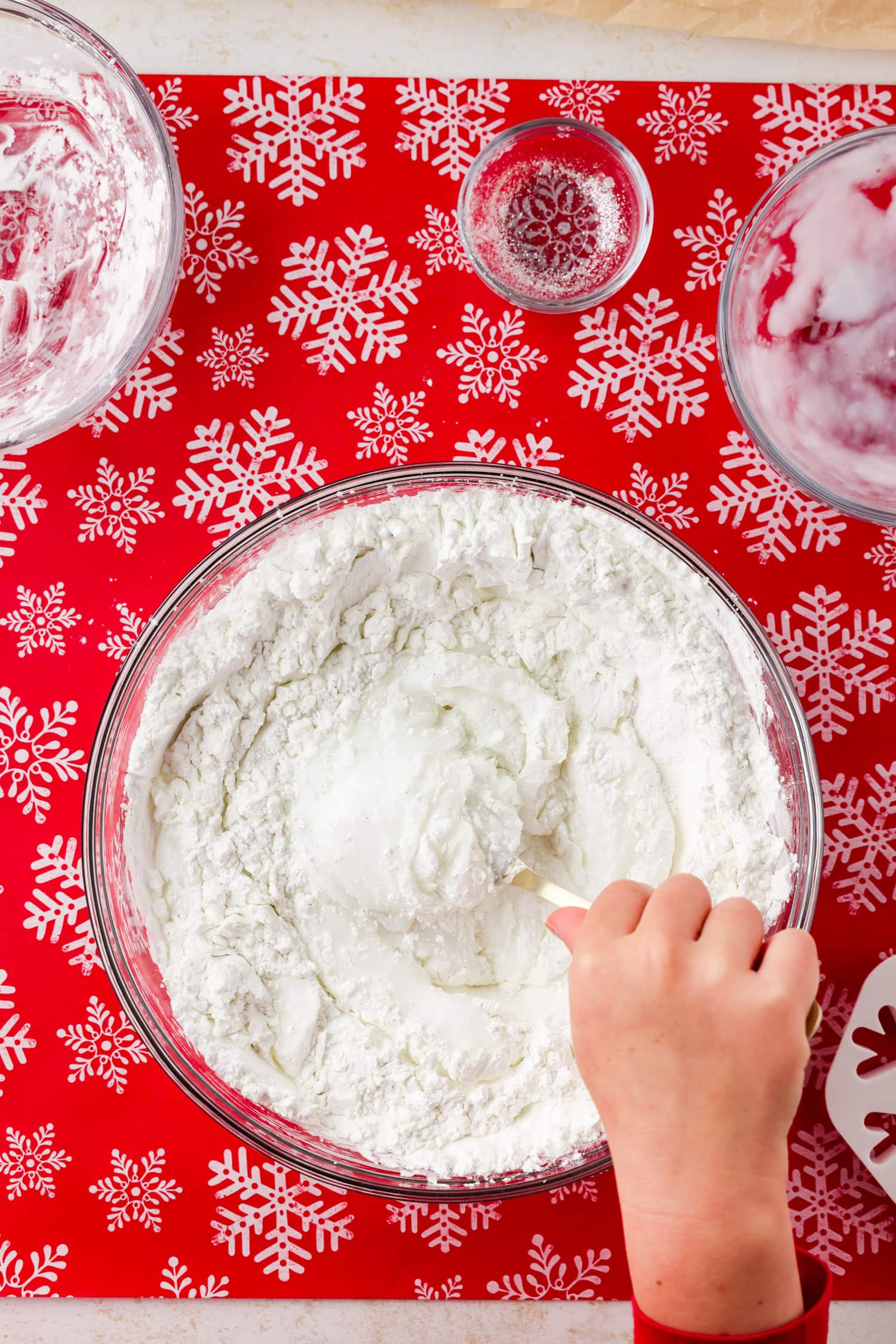 Overhead picture of hand stirring snow dough with spoon.