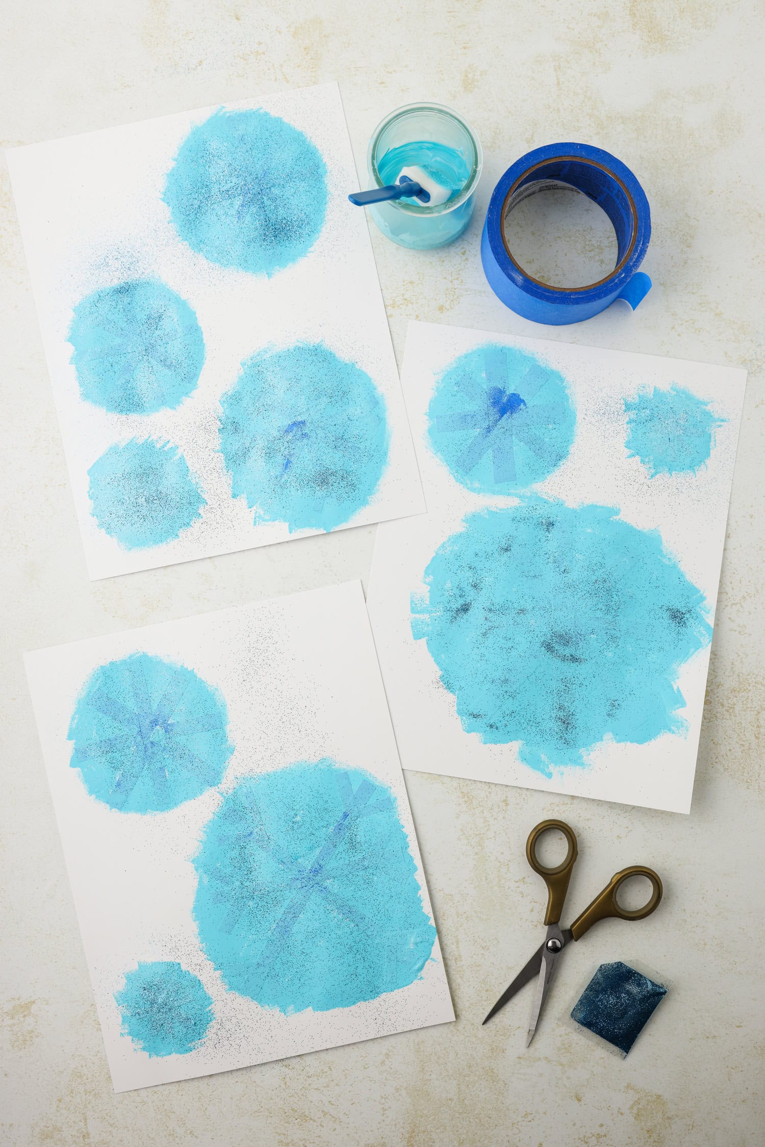 Overhead picture of the snowflakes painted on paper not cut out yet.