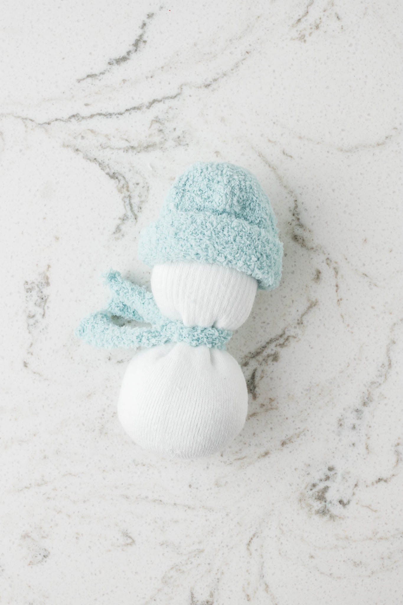 Picture of sock snowman with hand and scarf on.