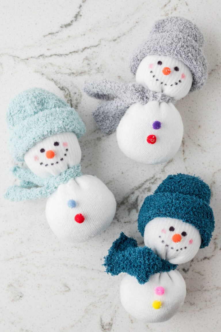 Picture of 3 completed snowman sock crafts completed laying down in a staggered pattern.
