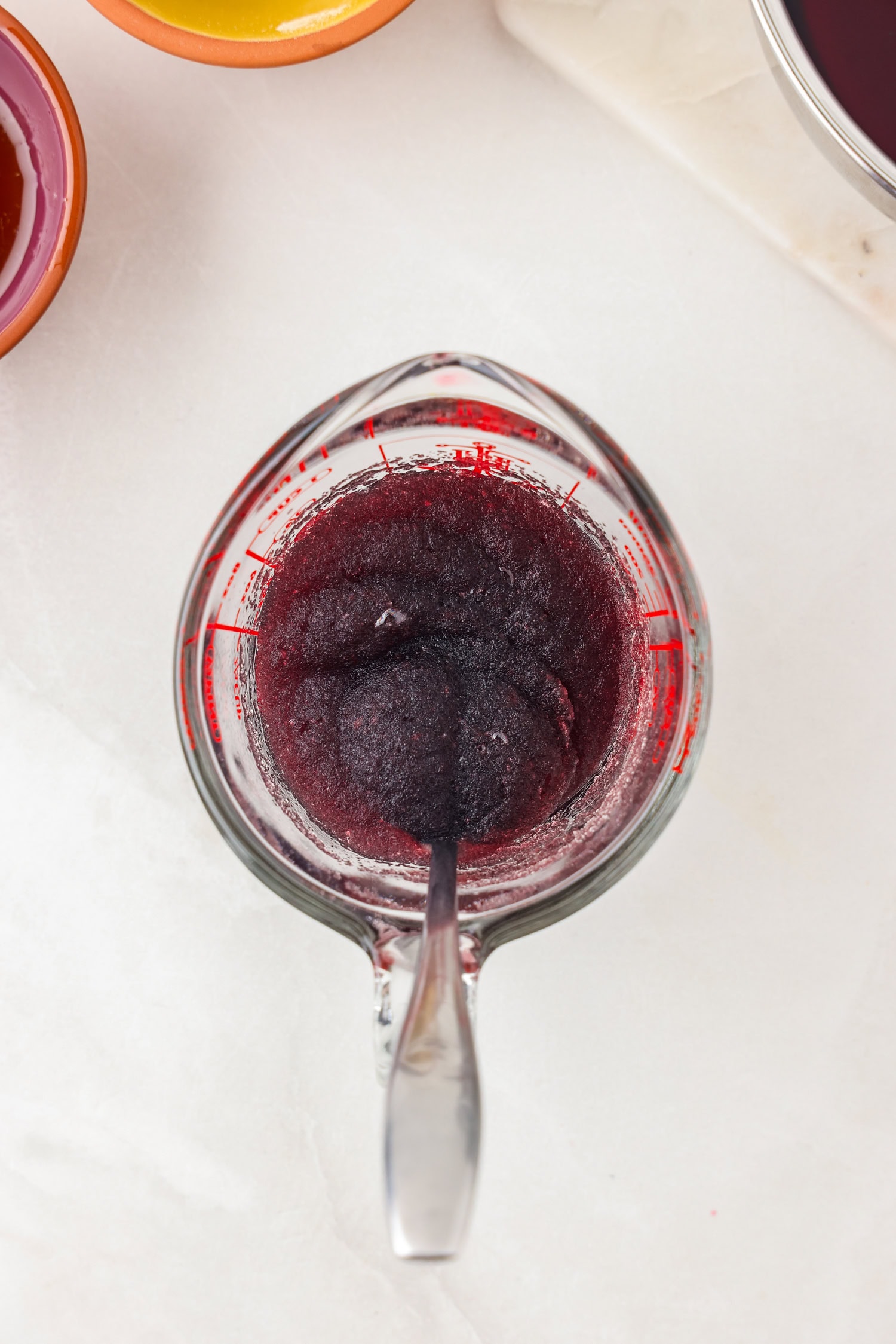 Picture of purple gummy bear ingredients being mixed in a glass measuring cup.
