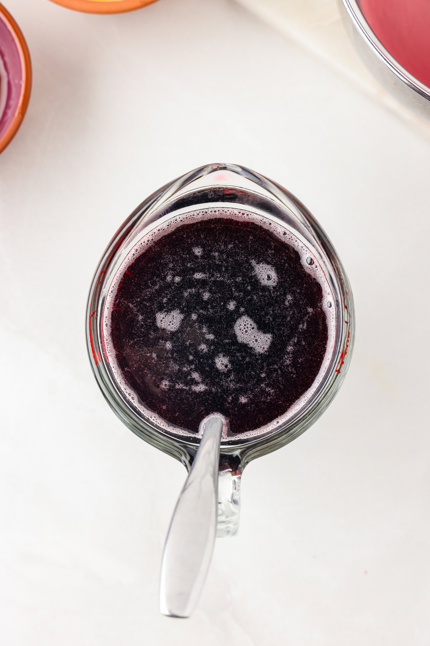 Picture of of purple grape juice in a glass measuring cup.