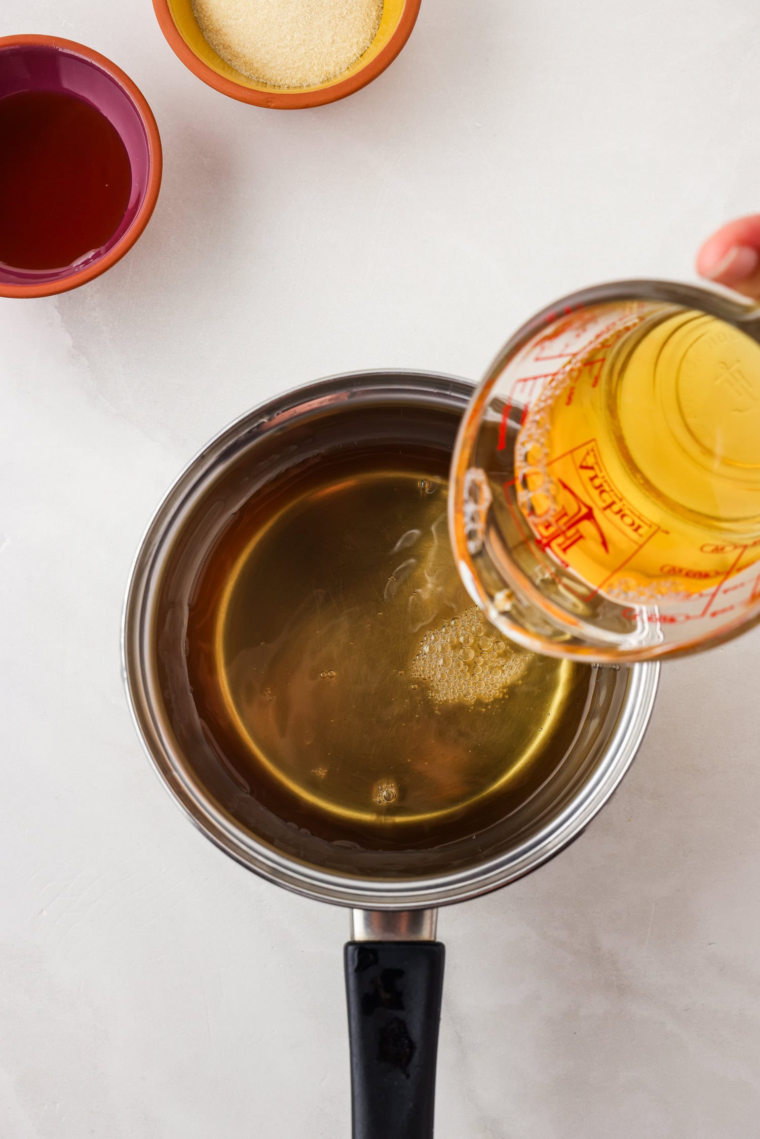 Picture of apple juice being poured into a sauce pan.