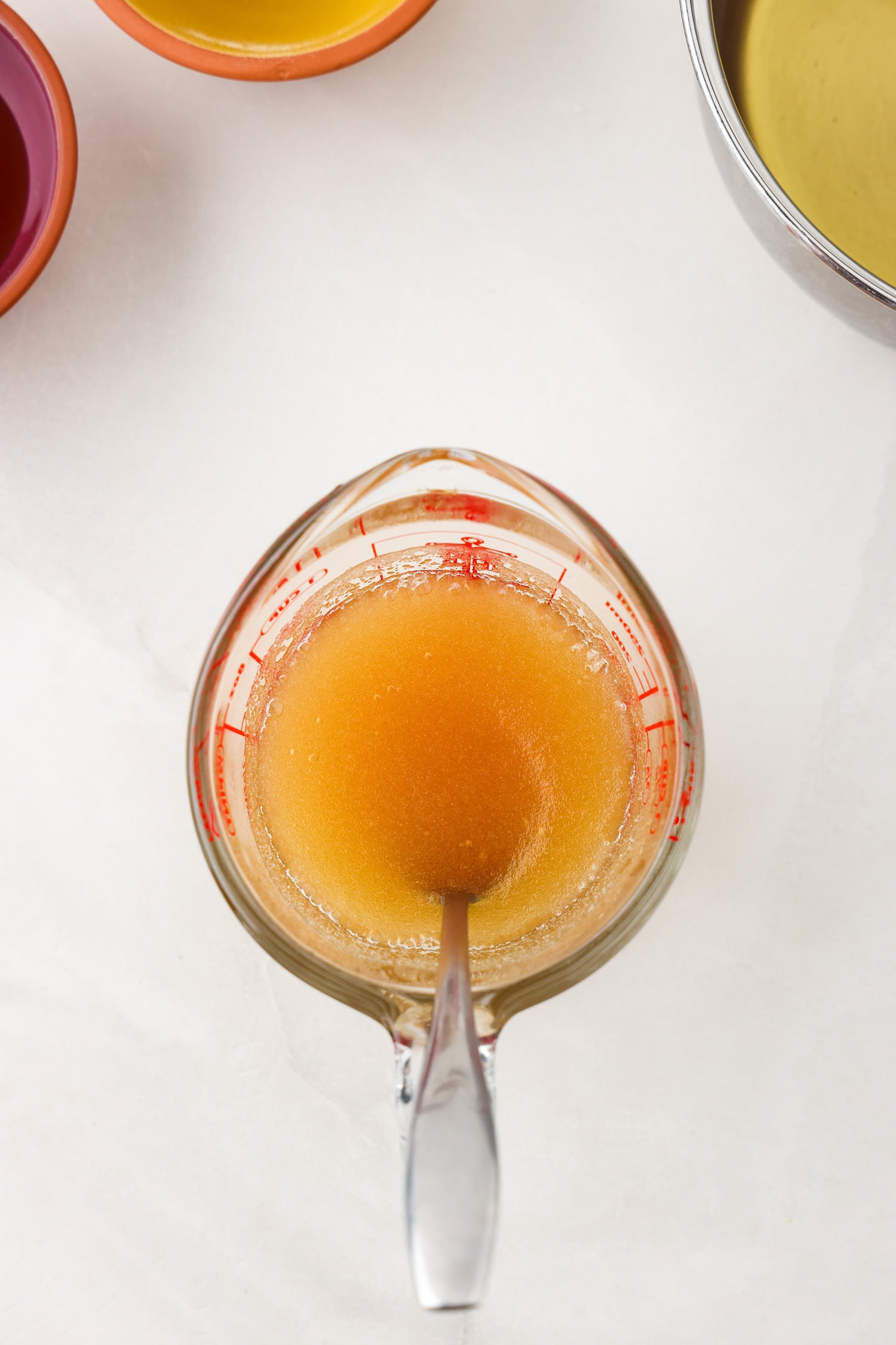 Picture of apple juice gummy bear ingredients being mixed in a glass measuring cup.