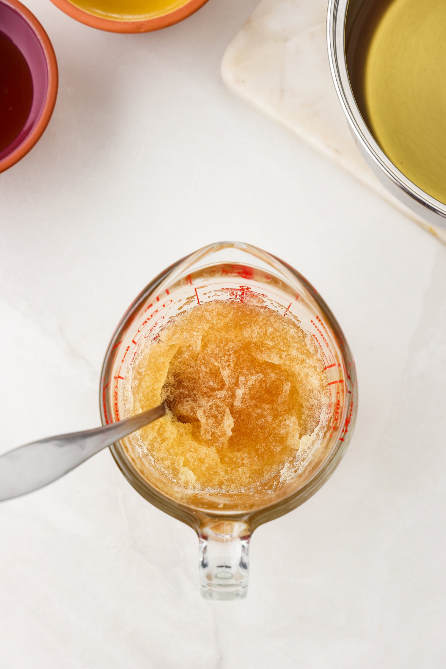 Picture of apple juice gummy bear ingredients being mixed in a glass measuring cup.
