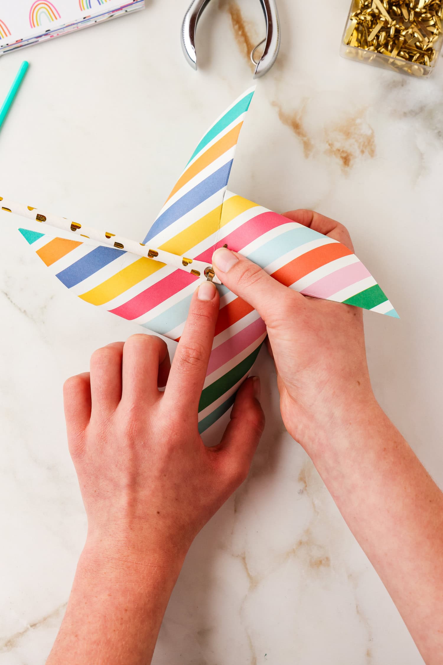 Paper fastener being fastened on the back side of the pinwheel.