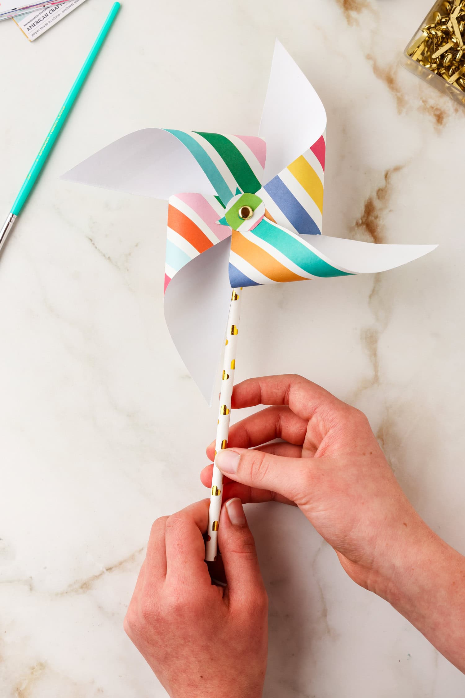 Paper straw being attached to pinwheel.