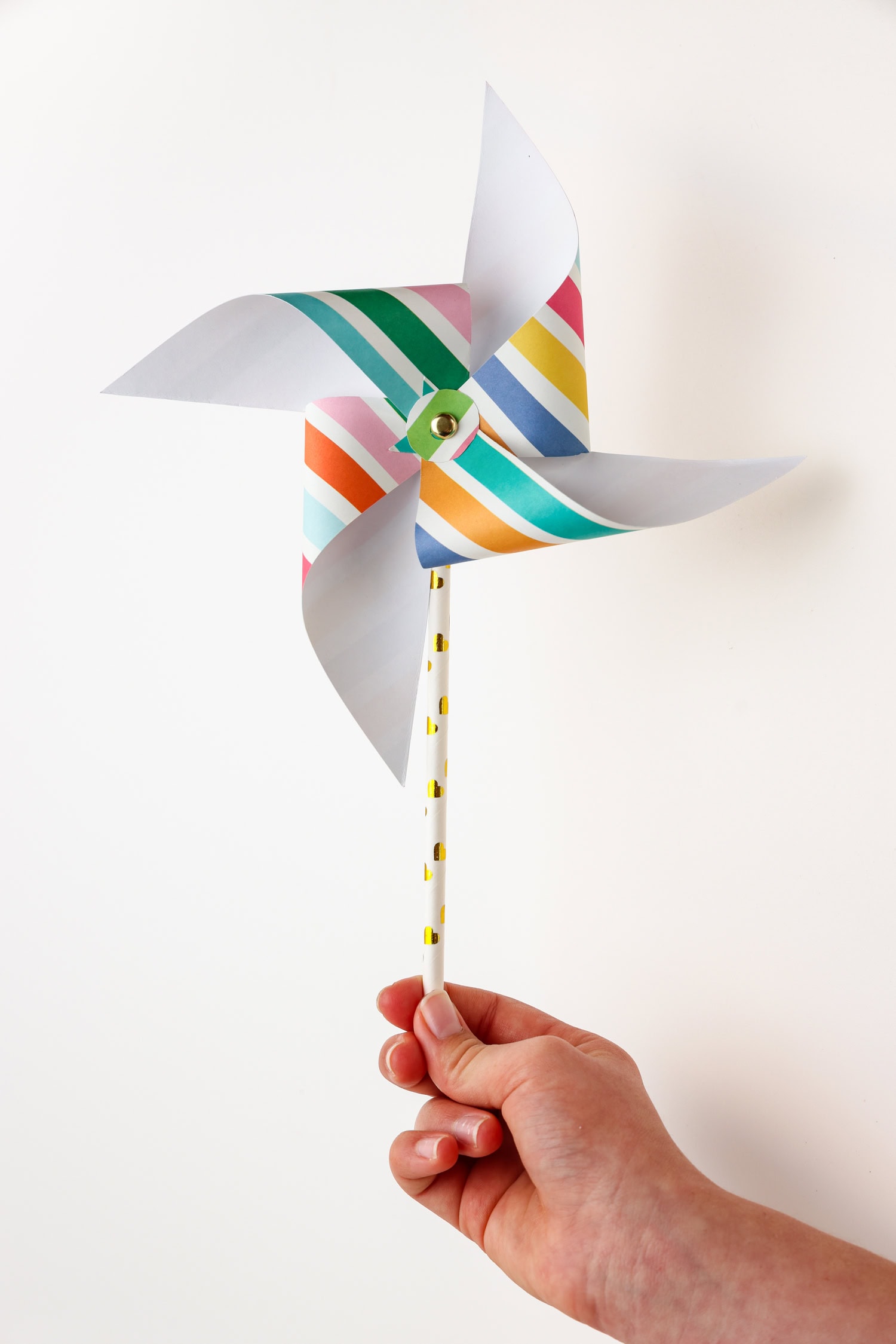 Hand holding completed paper pinwheel.