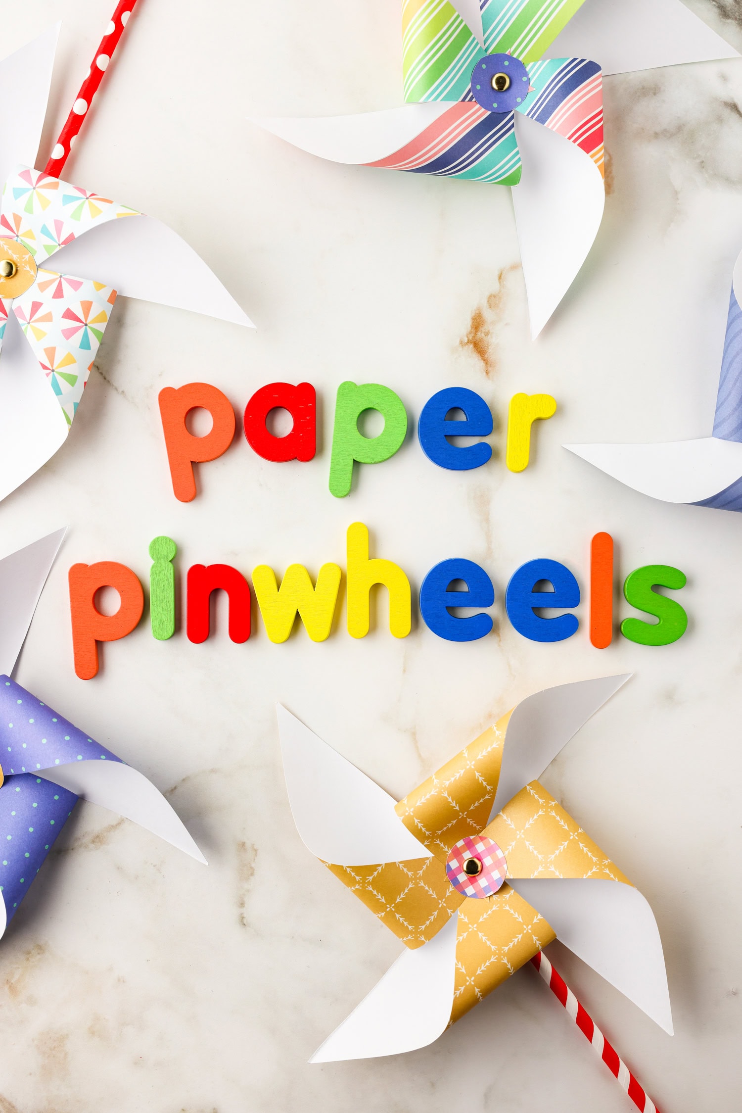 Completed paper pinwheels around letters spelling "Paper Pinwheels".