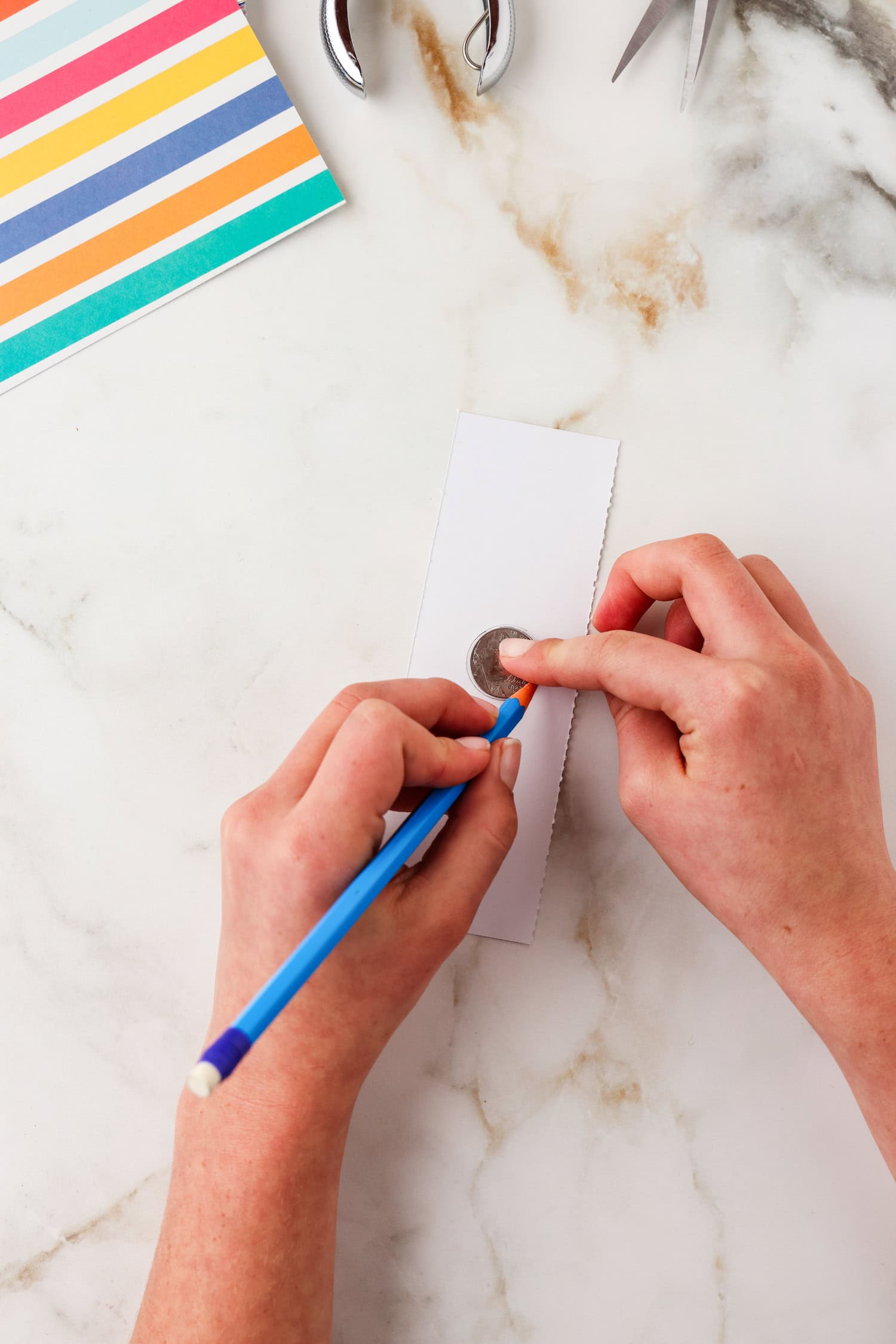 Tracing a coin on the white side of the cardstock paper.