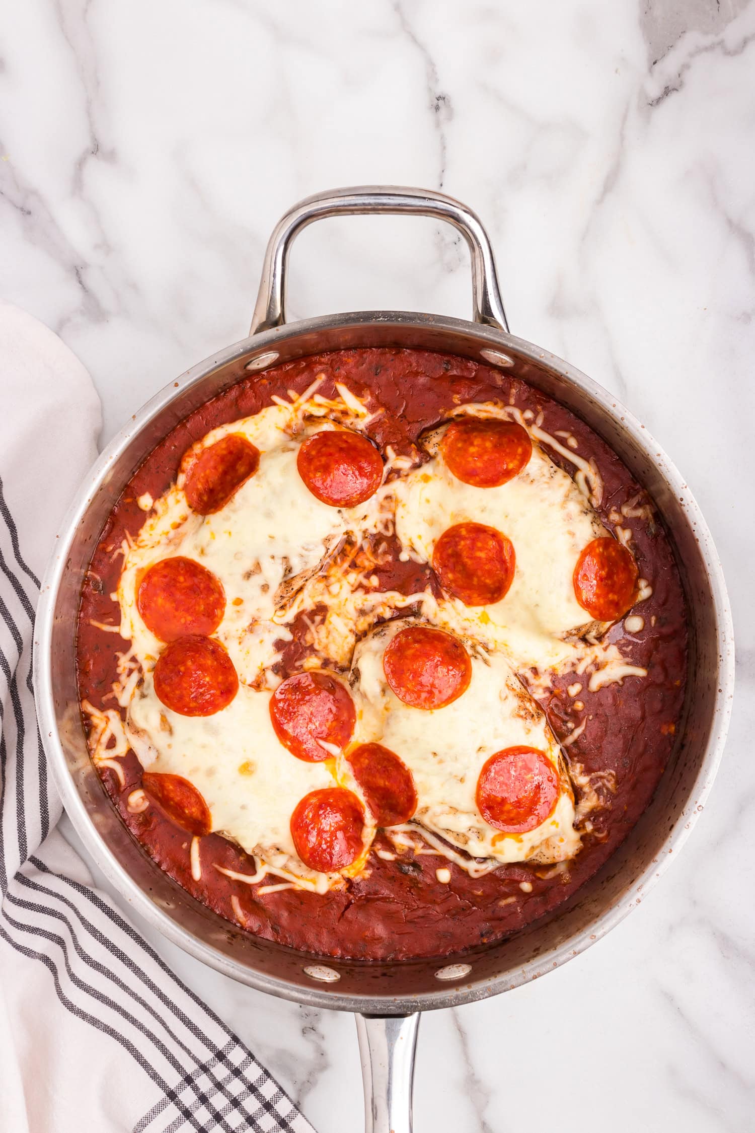 Overhead picture of pizza chicken with mozzarella cheese melted.