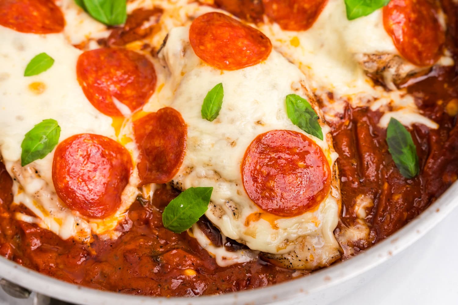 Close up picture of completed pizza chicken in a pan.