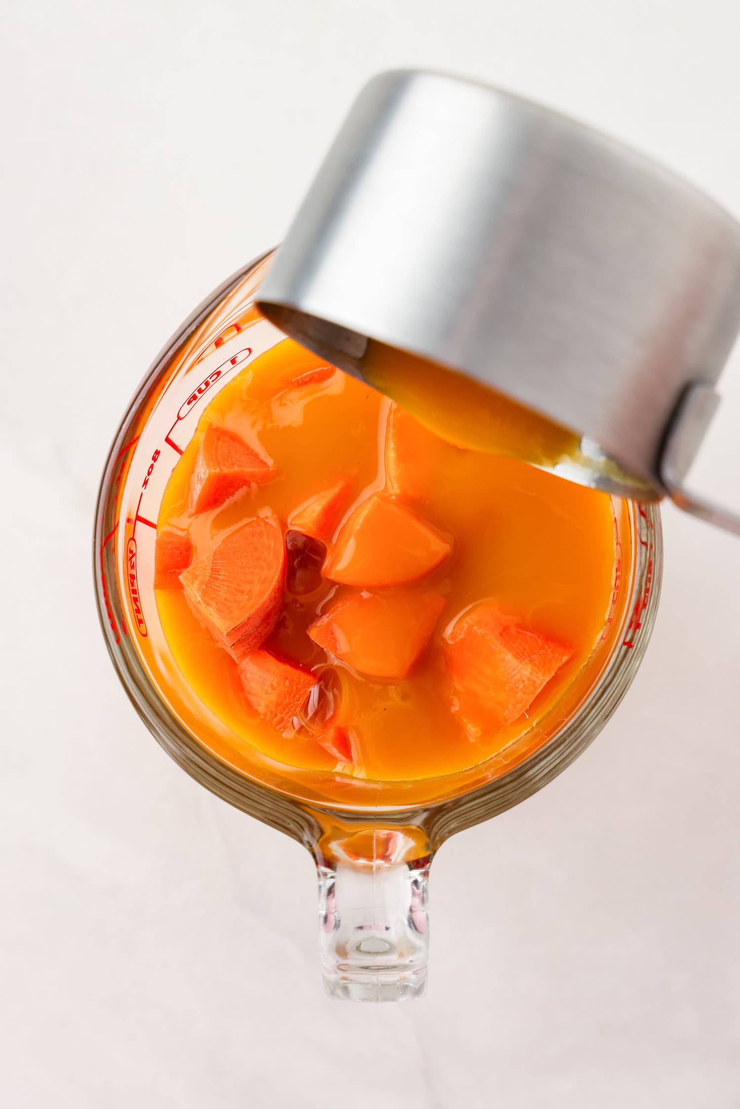 Picture of orange fruit mixture with liquid ingredients poured on top.