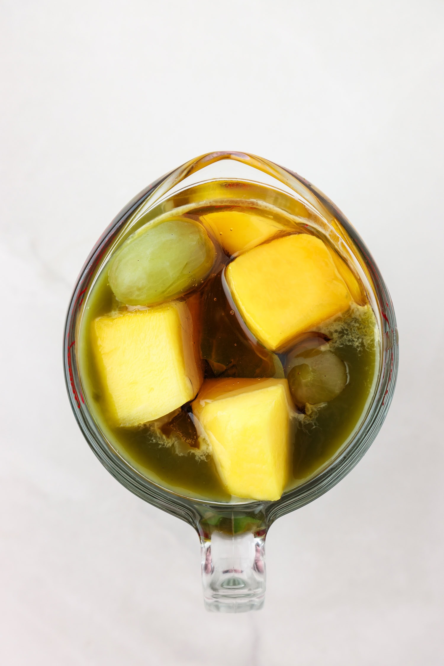 Picture of green fruit mixture with liquid ingredients poured on top.