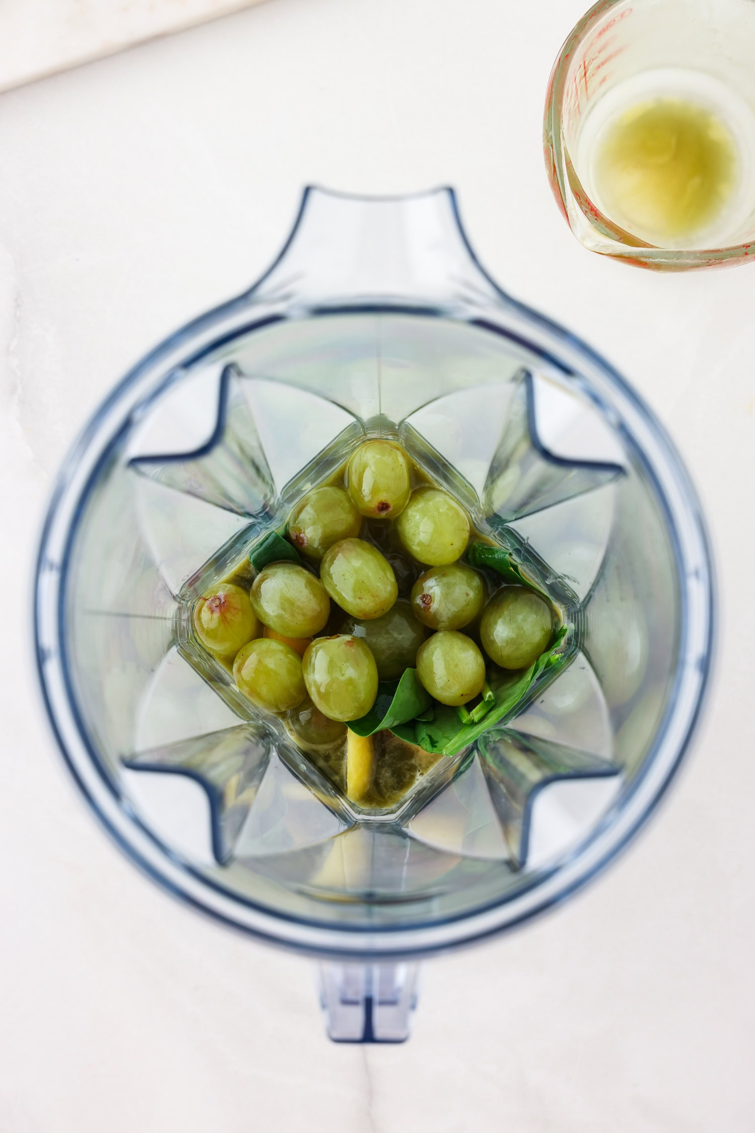Green fruit mixture in a blender.
