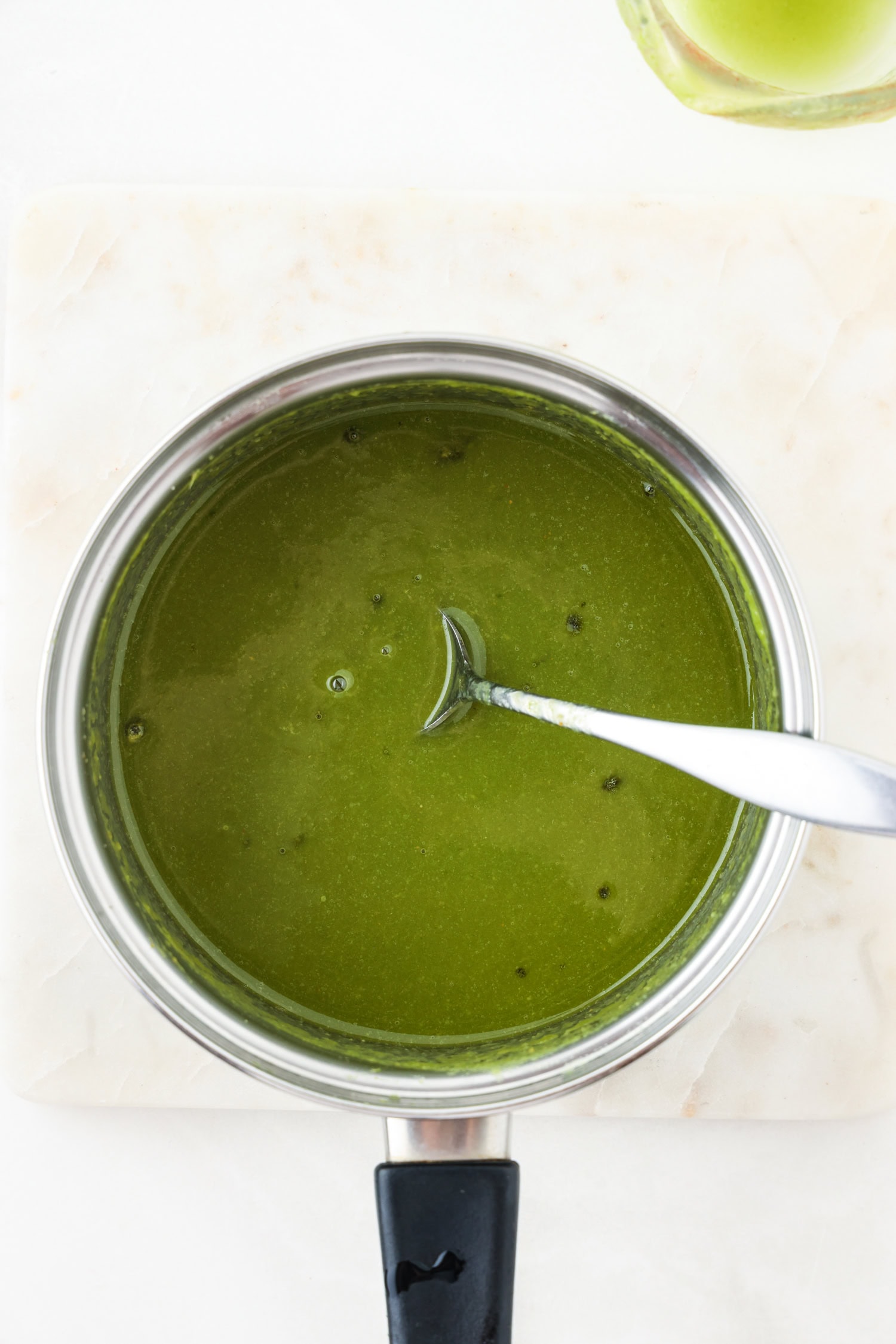 Green fruit mixture blended in a sauce pan.