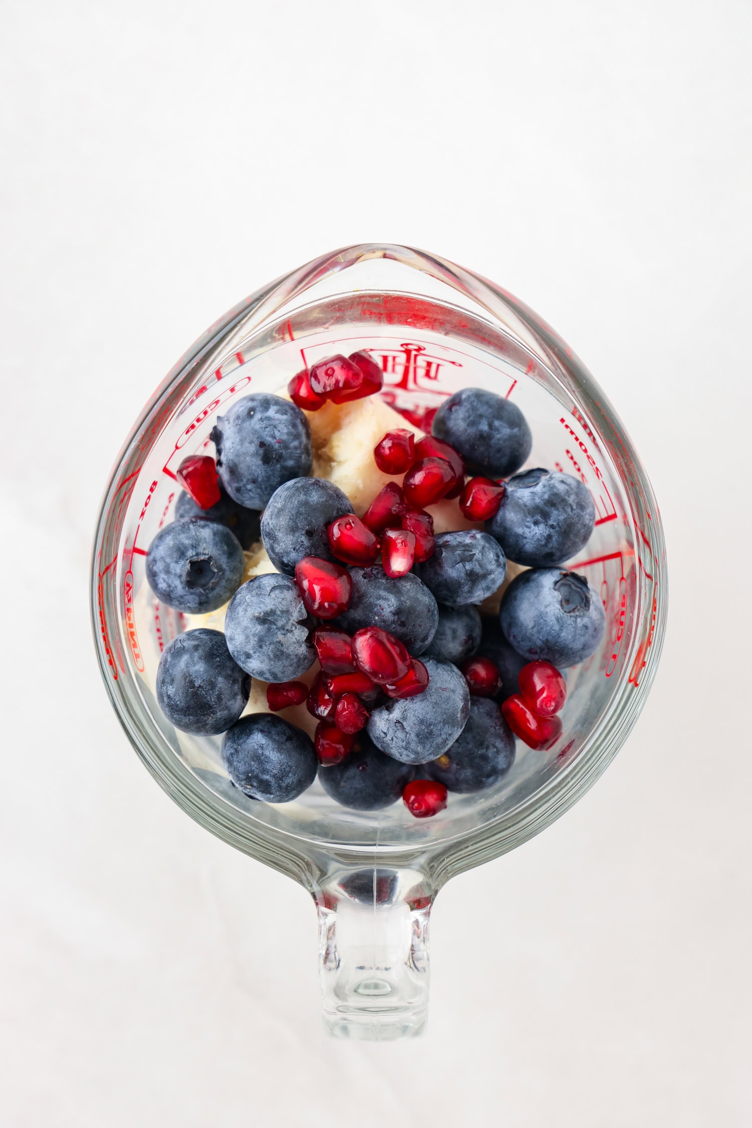Overhead picture of purple fruit mixture in a measuring glass.