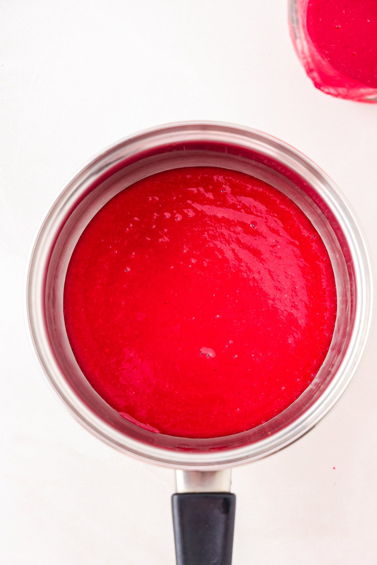 Red fruit mixture blended in a sauce pan.