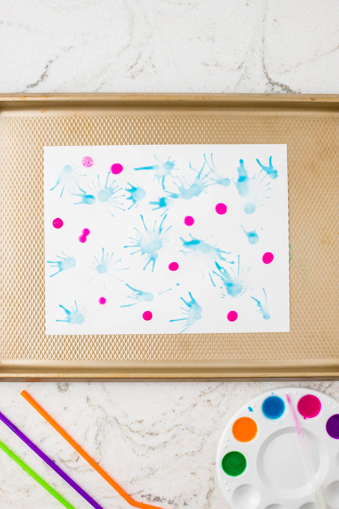 The same blue-streaked painting with additional hot pink paint drops added for contrast.